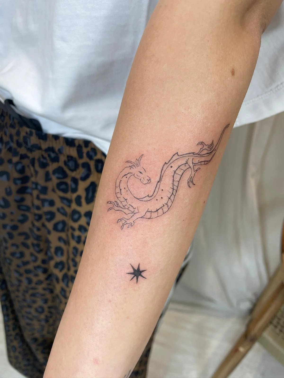 Tatuaje animales dragon con estrella antebrazo