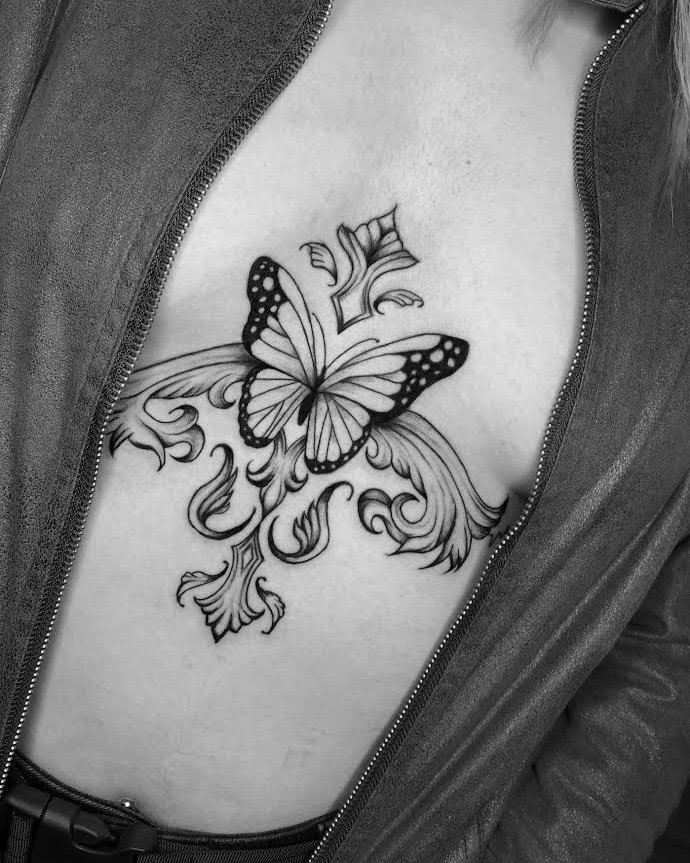 Tatuaje de mariposa con ornamentos floral en costilla, línea fina