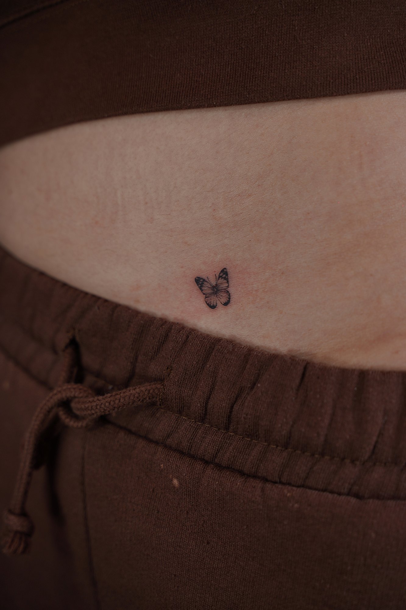 Tatuaje de mariposa en costilla, línea fina