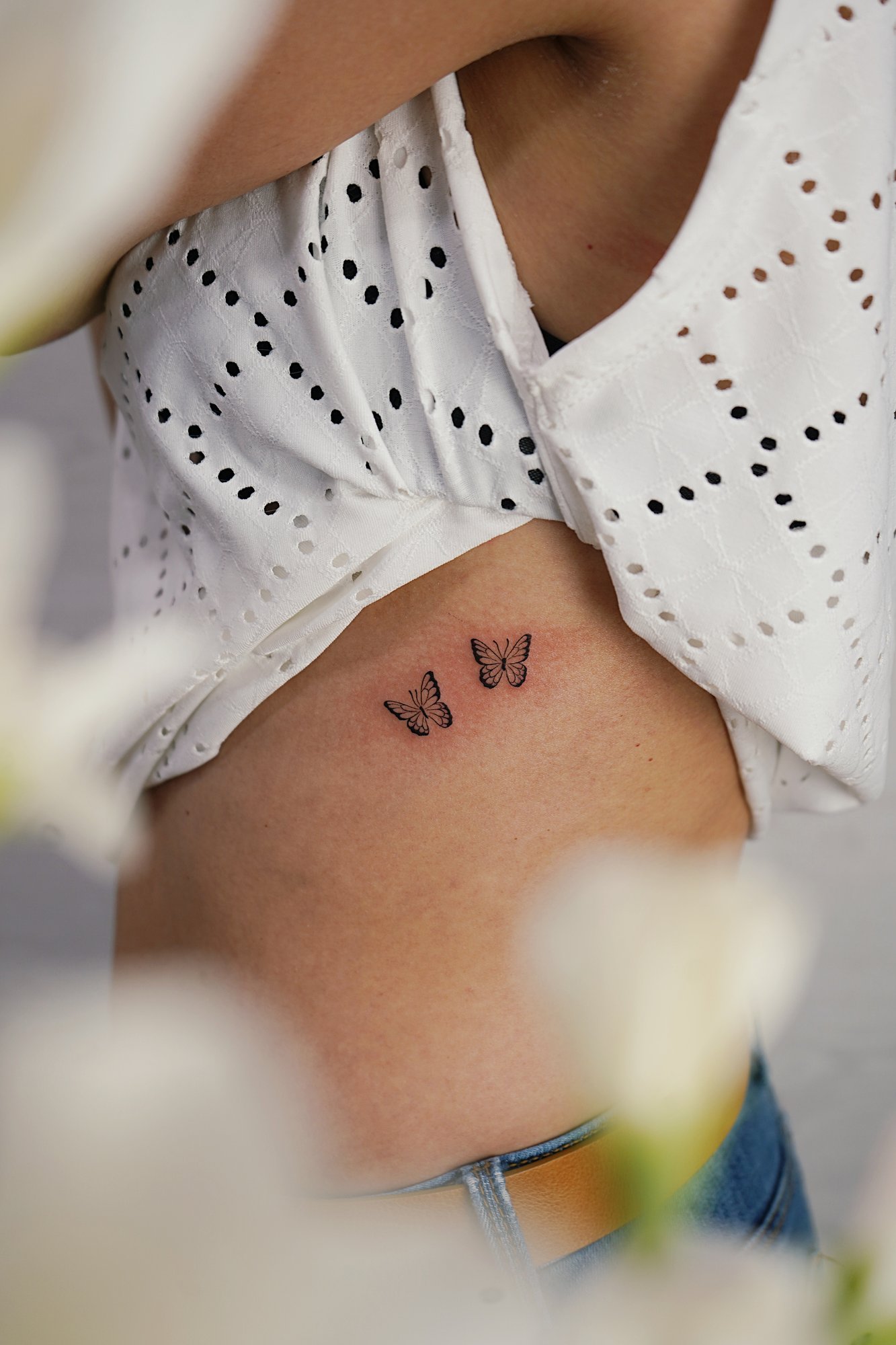 Tatuaje de mariposas dos en costilla, línea fina
