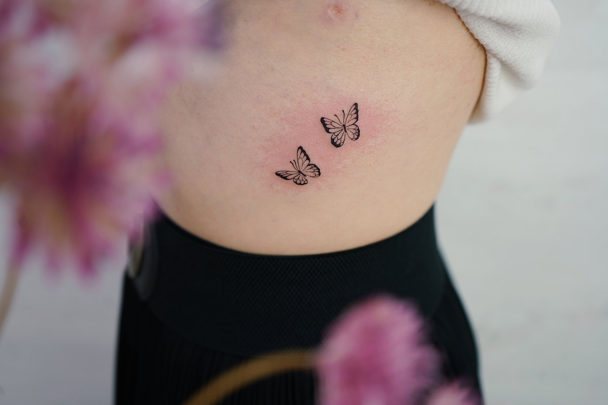 Tatuaje de mariposas en costilla, línea fina
