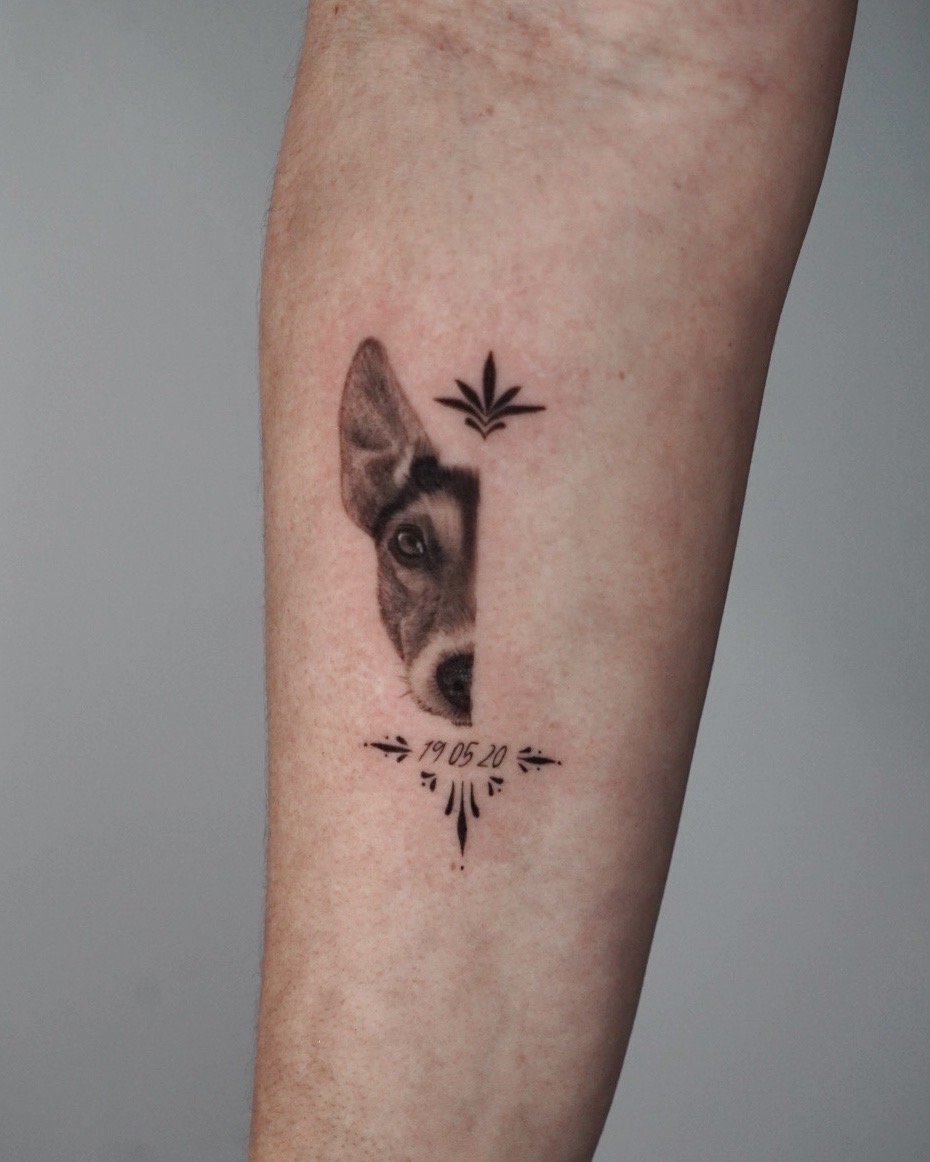 Tatuaje de medio rostro perro fecha en antebrazo, línea fina