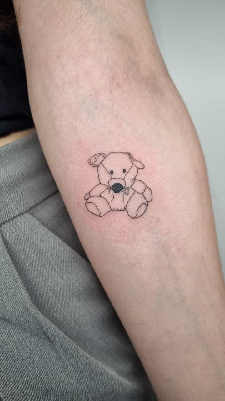 Tatuaje de peluche perro tierno lineal en antebrazo, línea fina