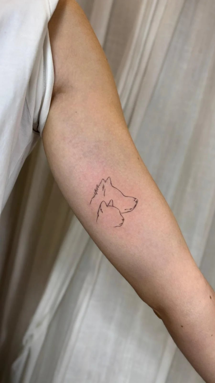 Tatuaje animales siluetas perro gato antebrazo