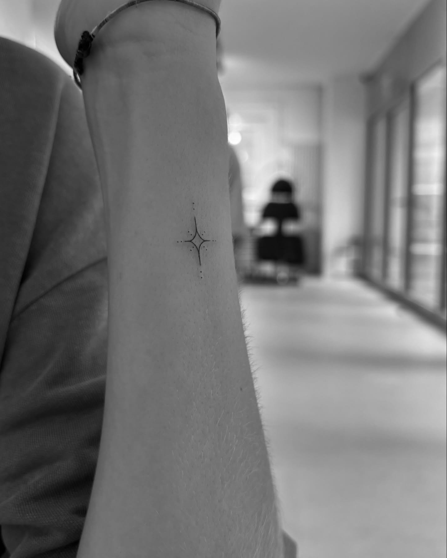 Tatuaje de estrella en antebrazo, línea fina Sinkply Madrid