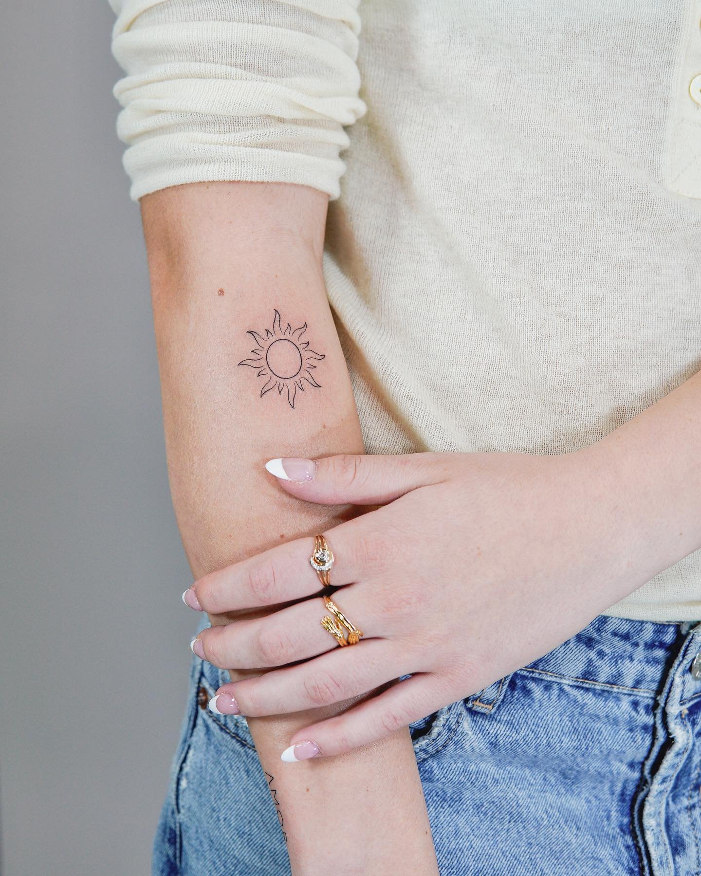 Tatuaje de sol en antebrazo, línea fina Sinkply Madrid