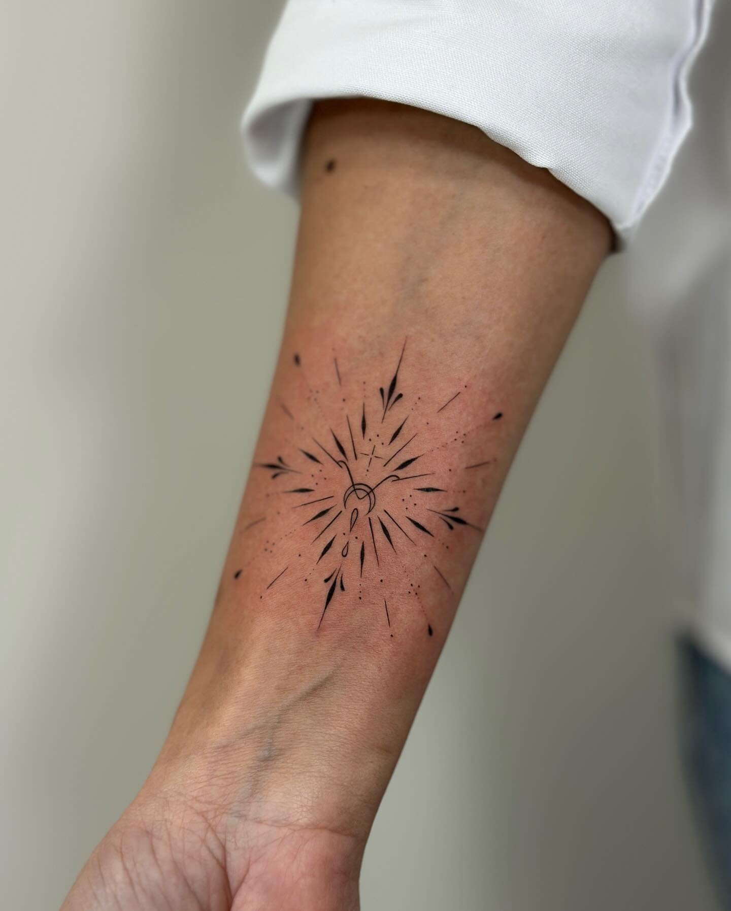 Tatuaje de sol en antebrazo, línea fina Sinkply Madrid