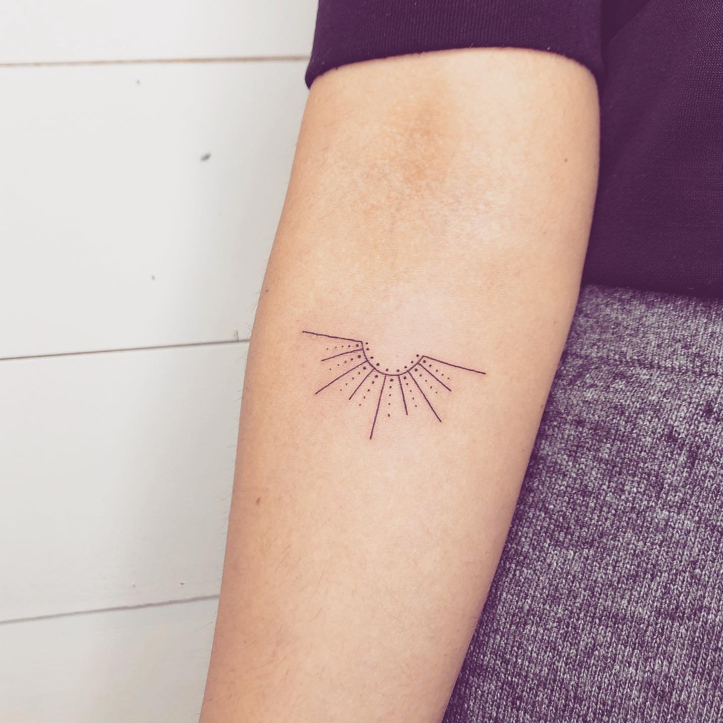 Tatuaje de sol en antebrazo, línea fina Sinkply Madrid