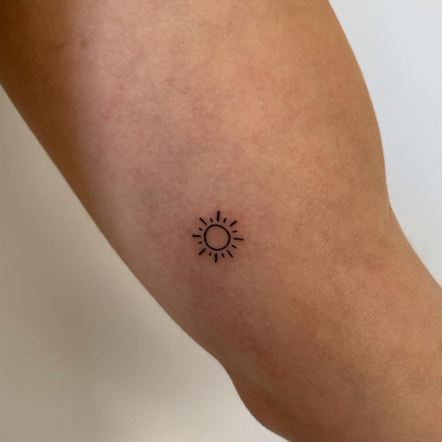Tatuaje de sol en antebrazo, línea fina Sinkply Madrid