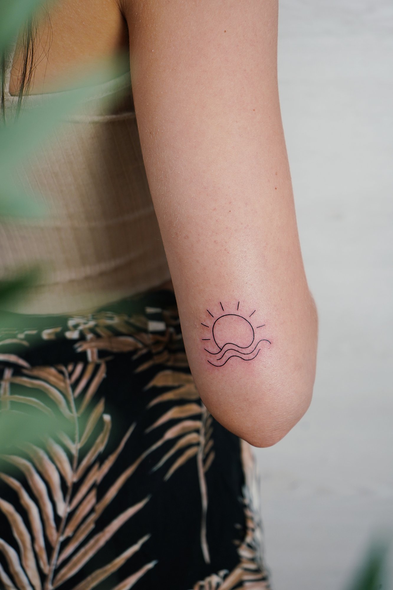 Tatuaje de atardecer sol luna en codo, línea fina