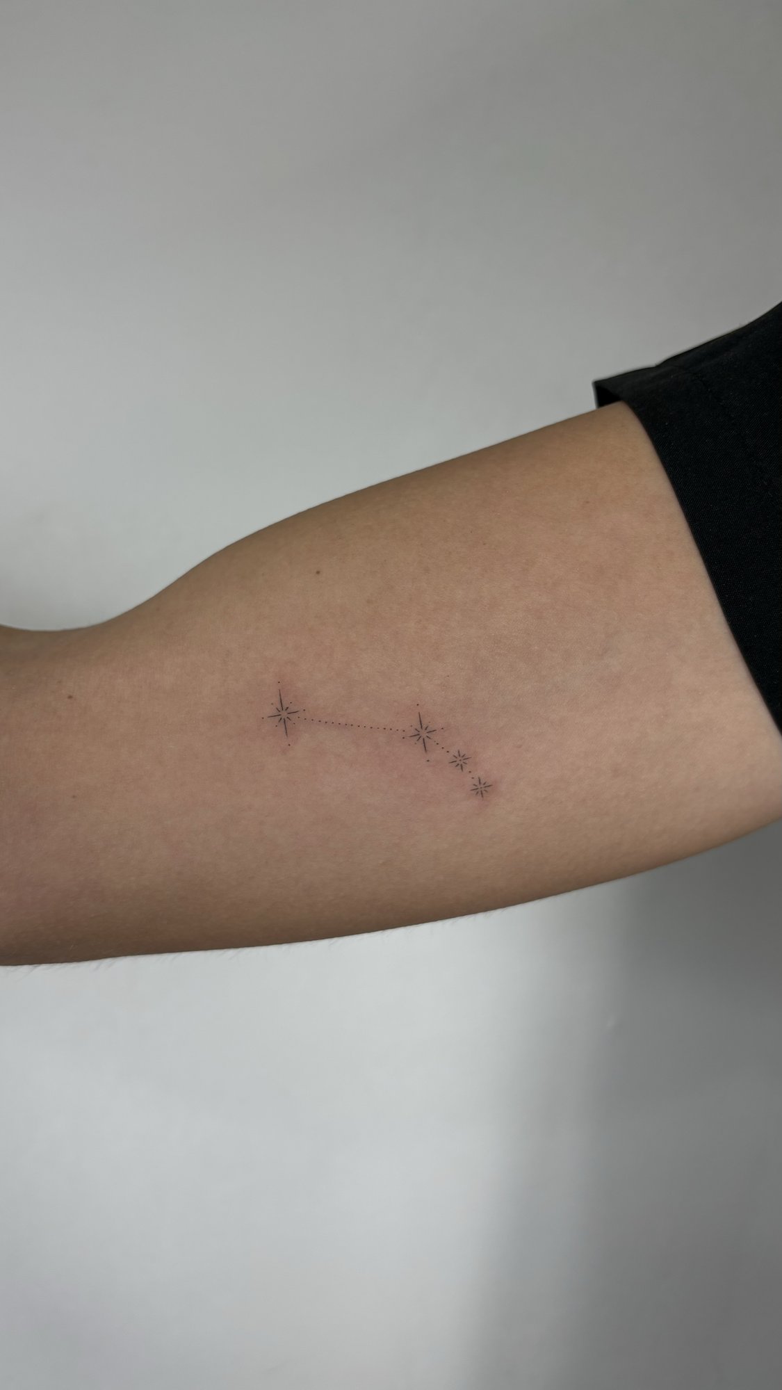 Tatuaje de constelacion estrellas conecta en brazo, línea fina