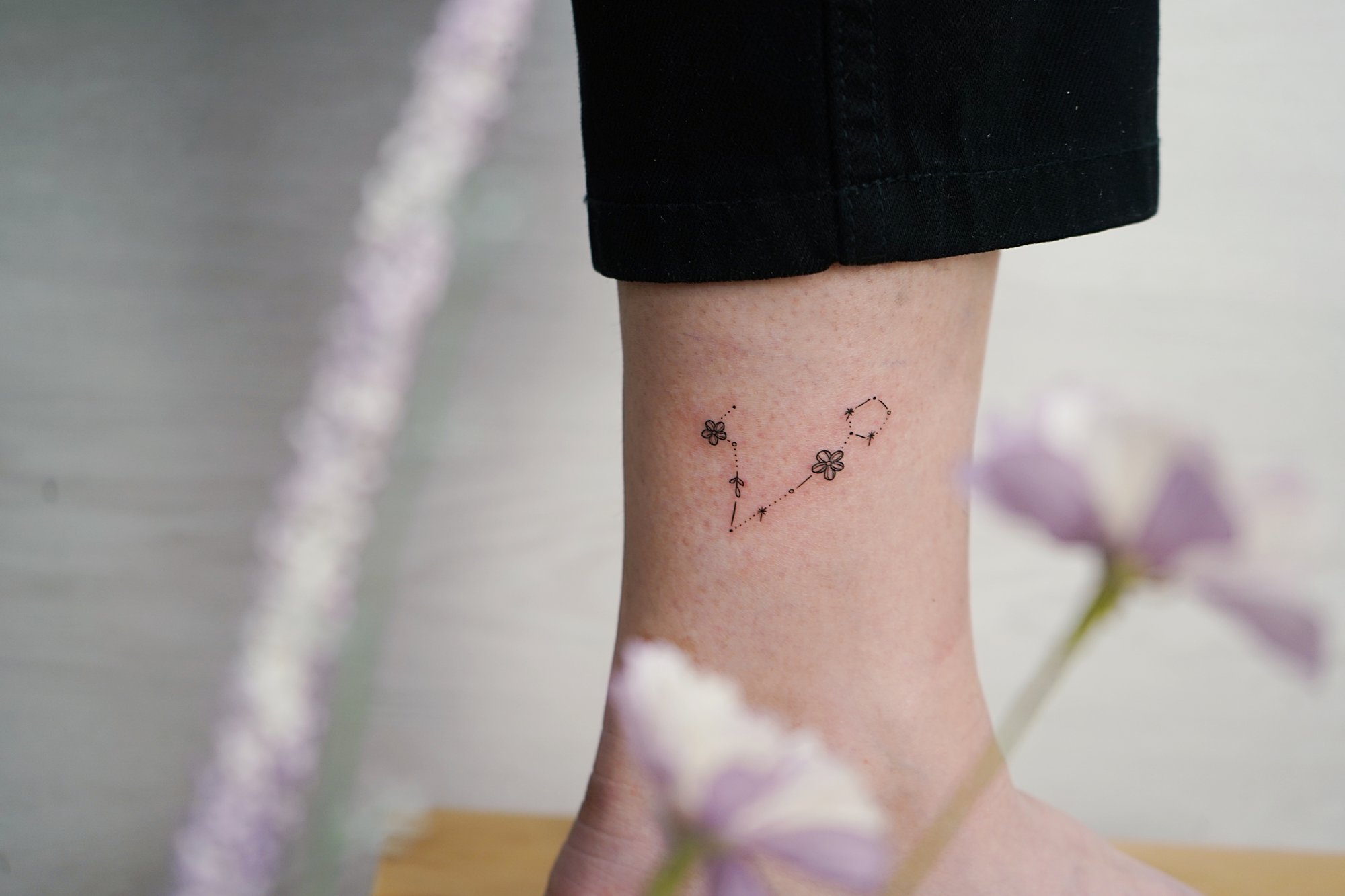Tatuaje de constelacion en tobillo, línea fina