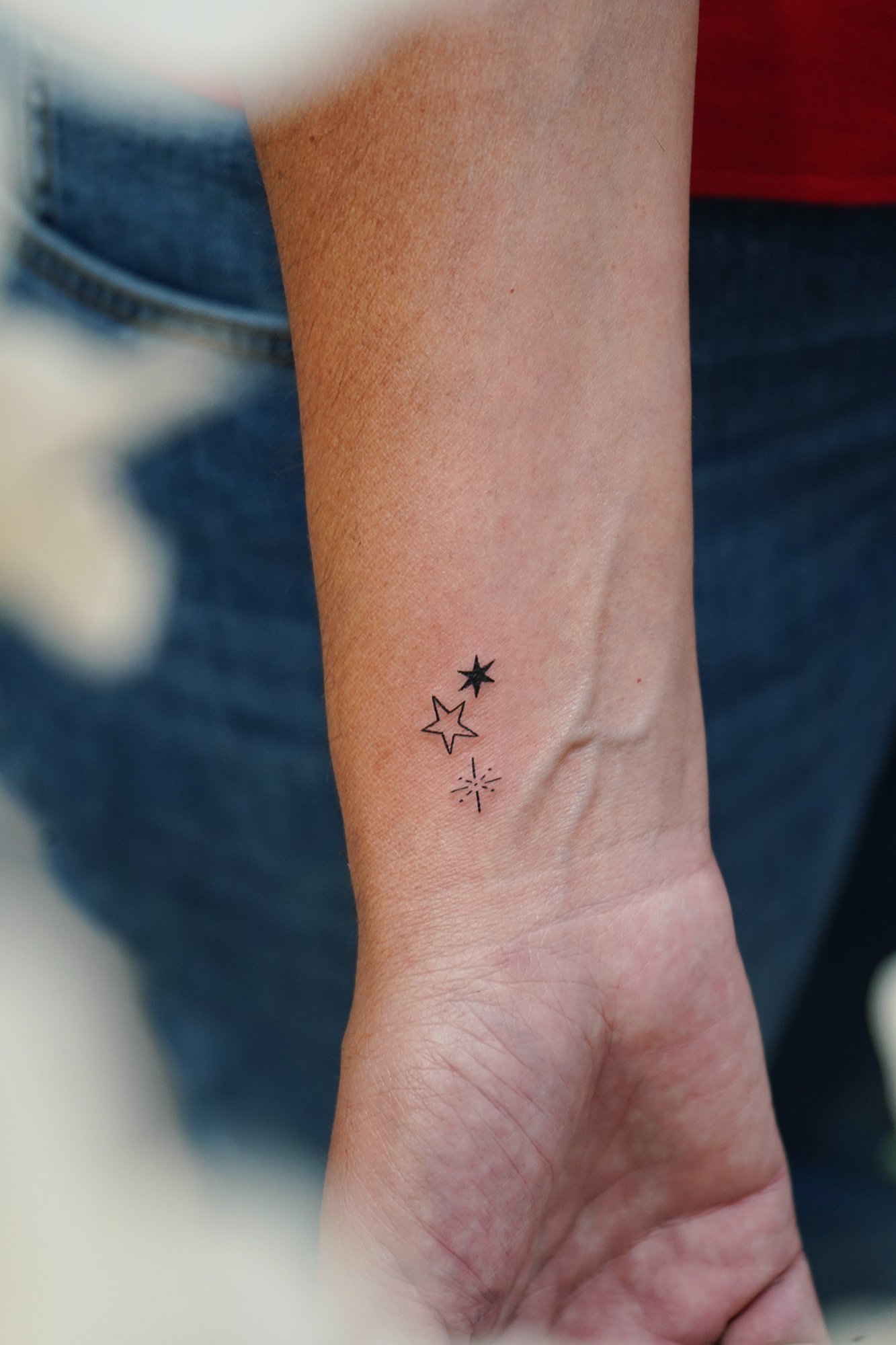 Tatuaje de estrellas en muneca, línea fina