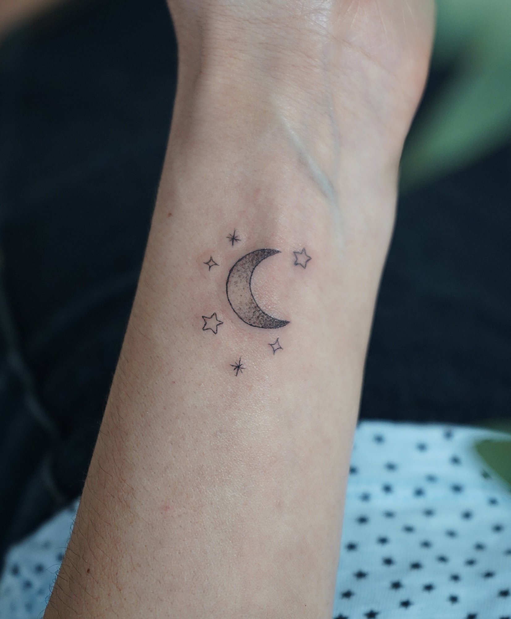Tatuaje de luna estrellas en muneca, línea fina