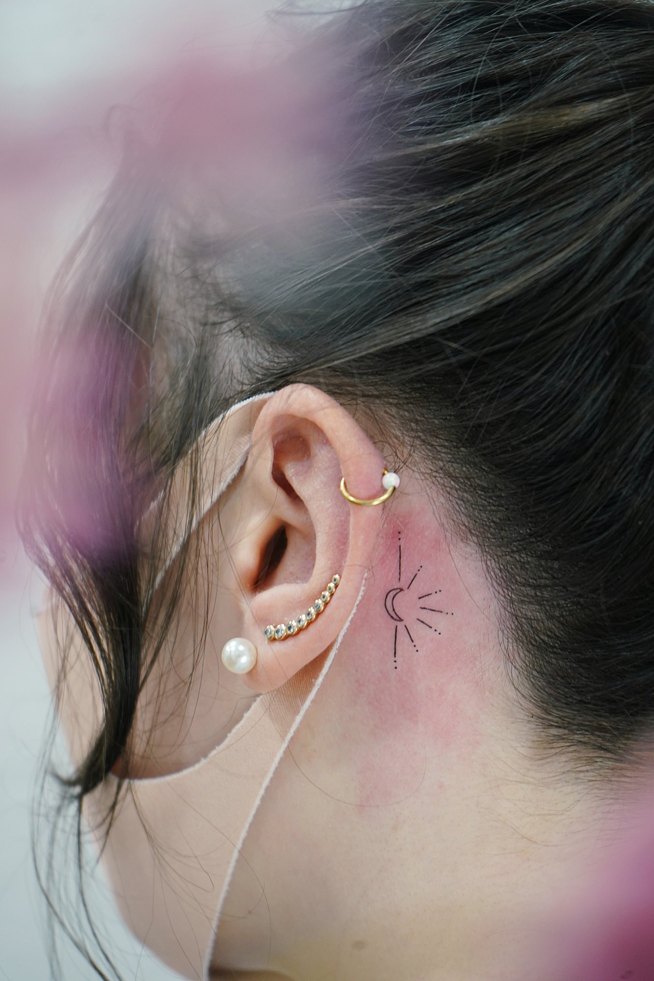 Tatuaje de luna en detras oreja, línea fina