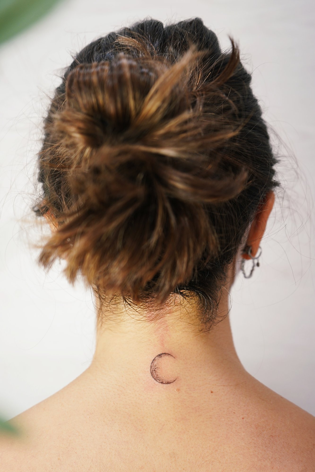 Tatuaje de luna en nuca, línea fina