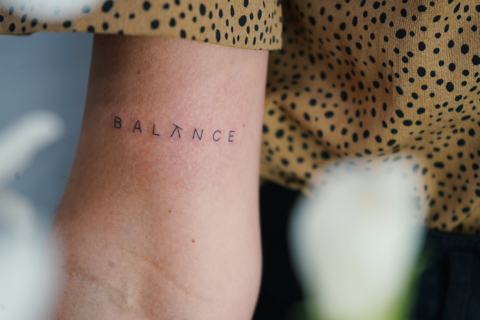 Tatuaje de simbolo zodiaco en detras oreja, línea fina