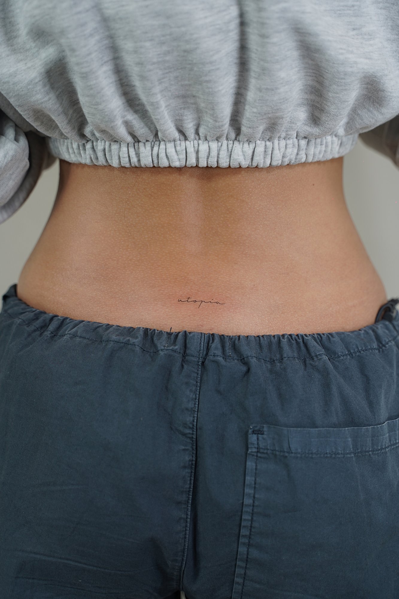 Tatuaje de simbolo zodiaco en detras oreja, línea fina