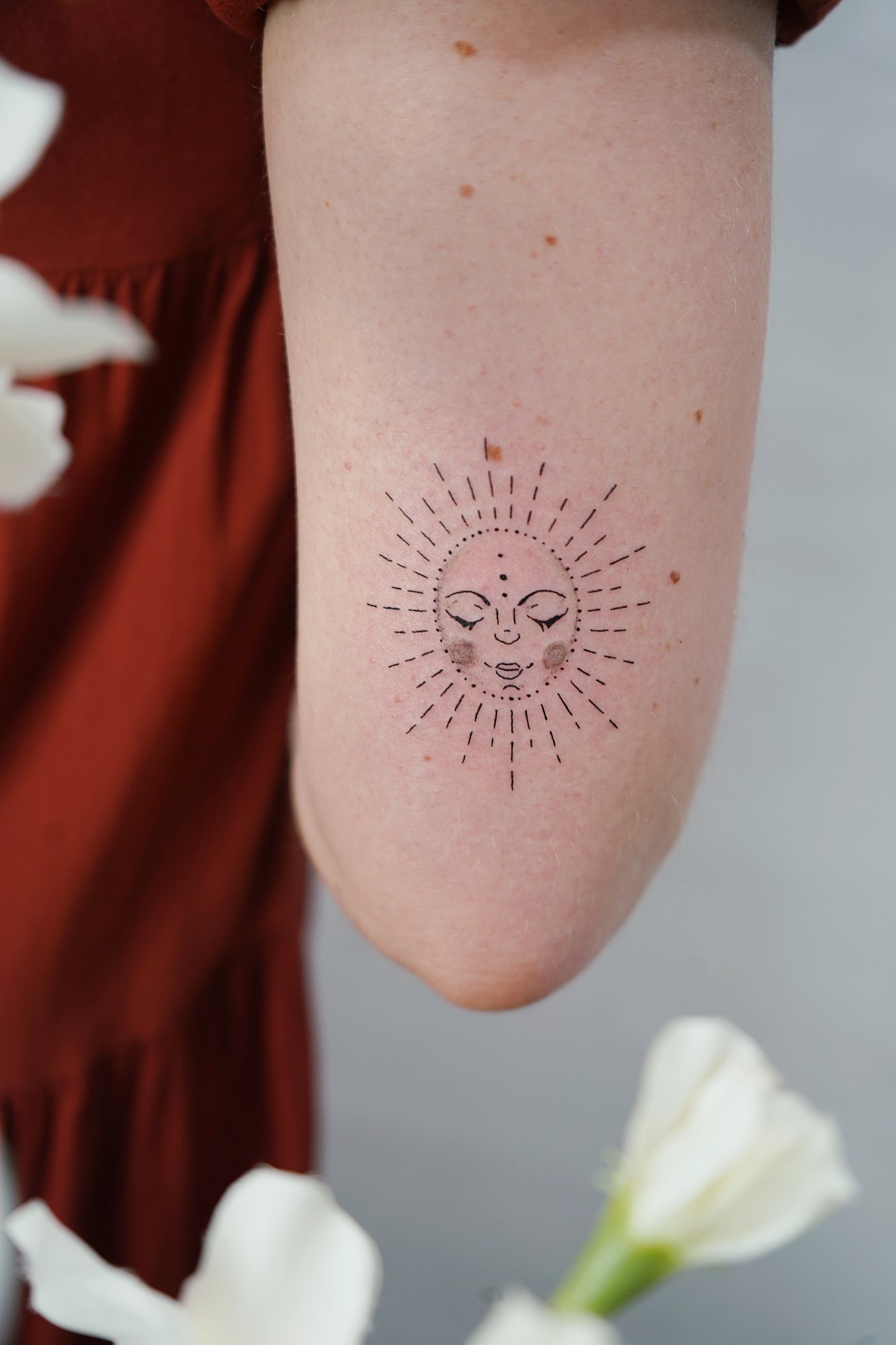 Tatuaje de sol lineal en codo, línea fina