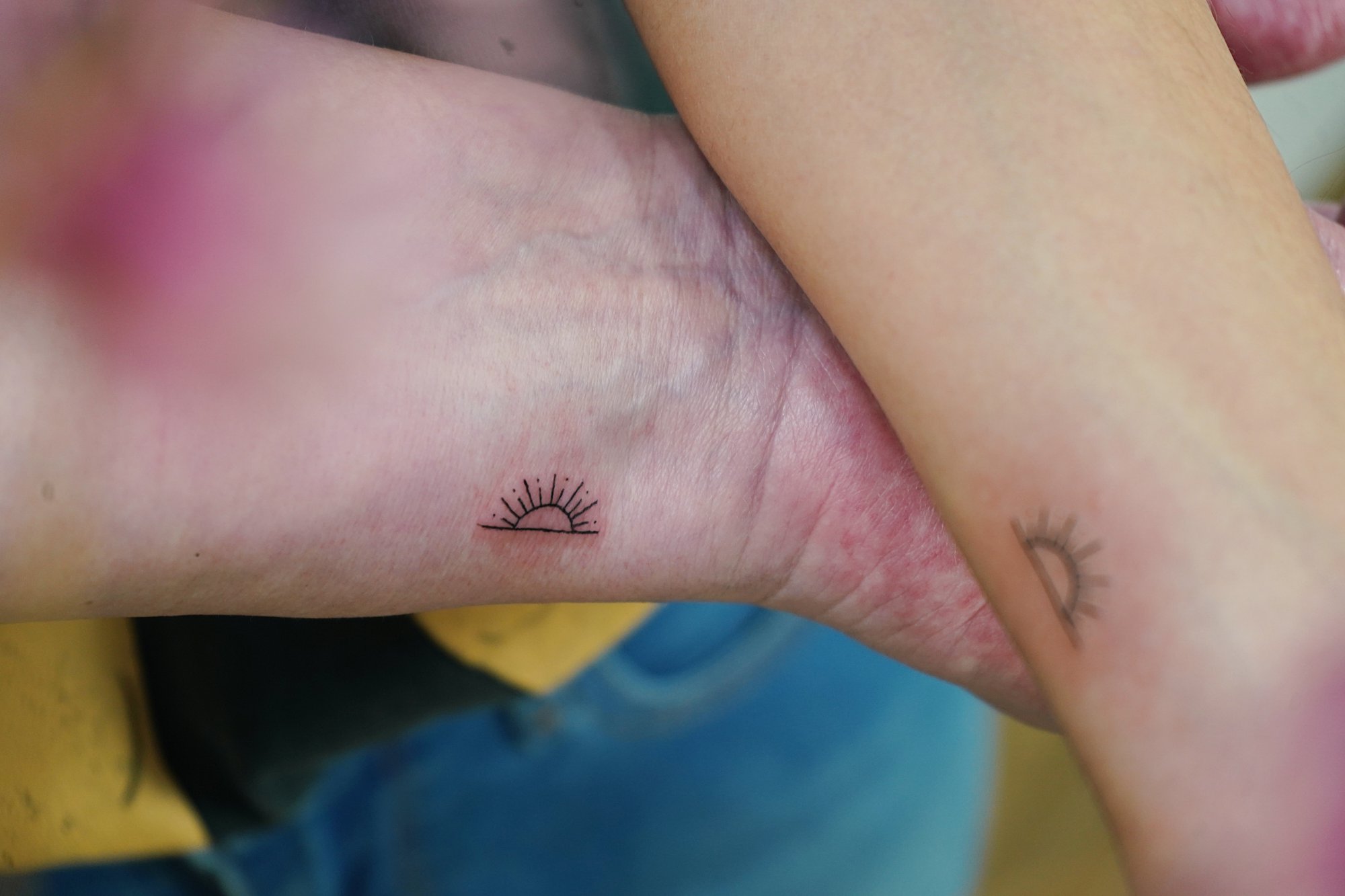 Tatuaje de sol en muneca, línea fina