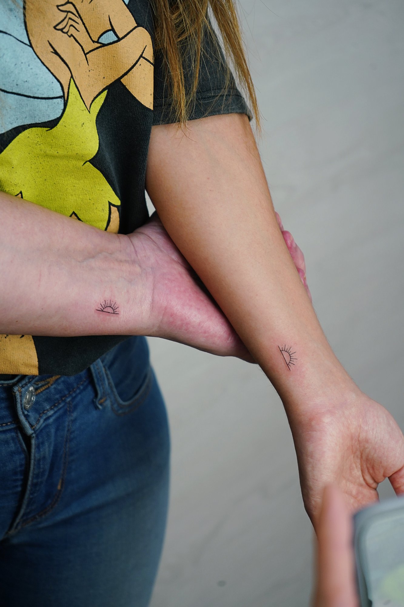 Tatuaje de soles en muneca, línea fina