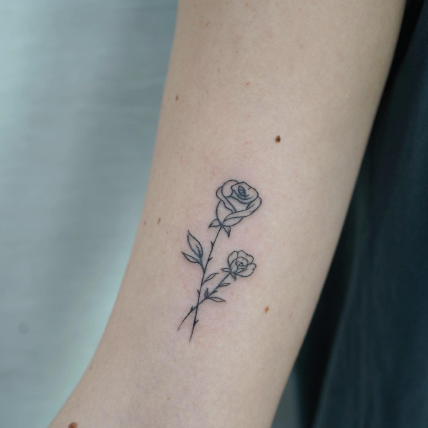 Tatuaje de flor en antebrazo, línea fina Sinkply Madrid