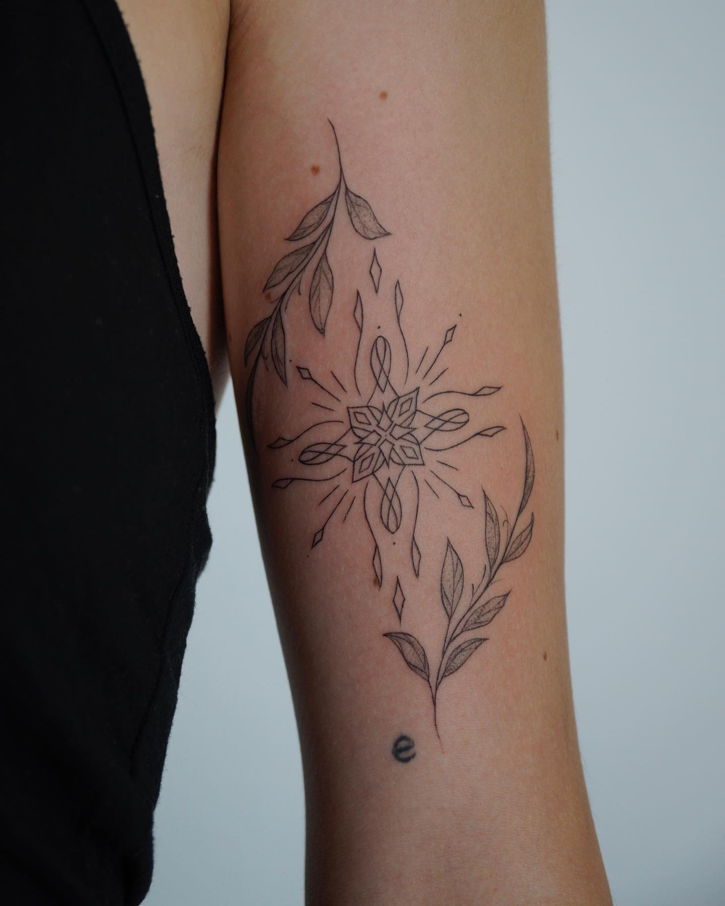 Tatuaje de flor en antebrazo, línea fina Sinkply Madrid