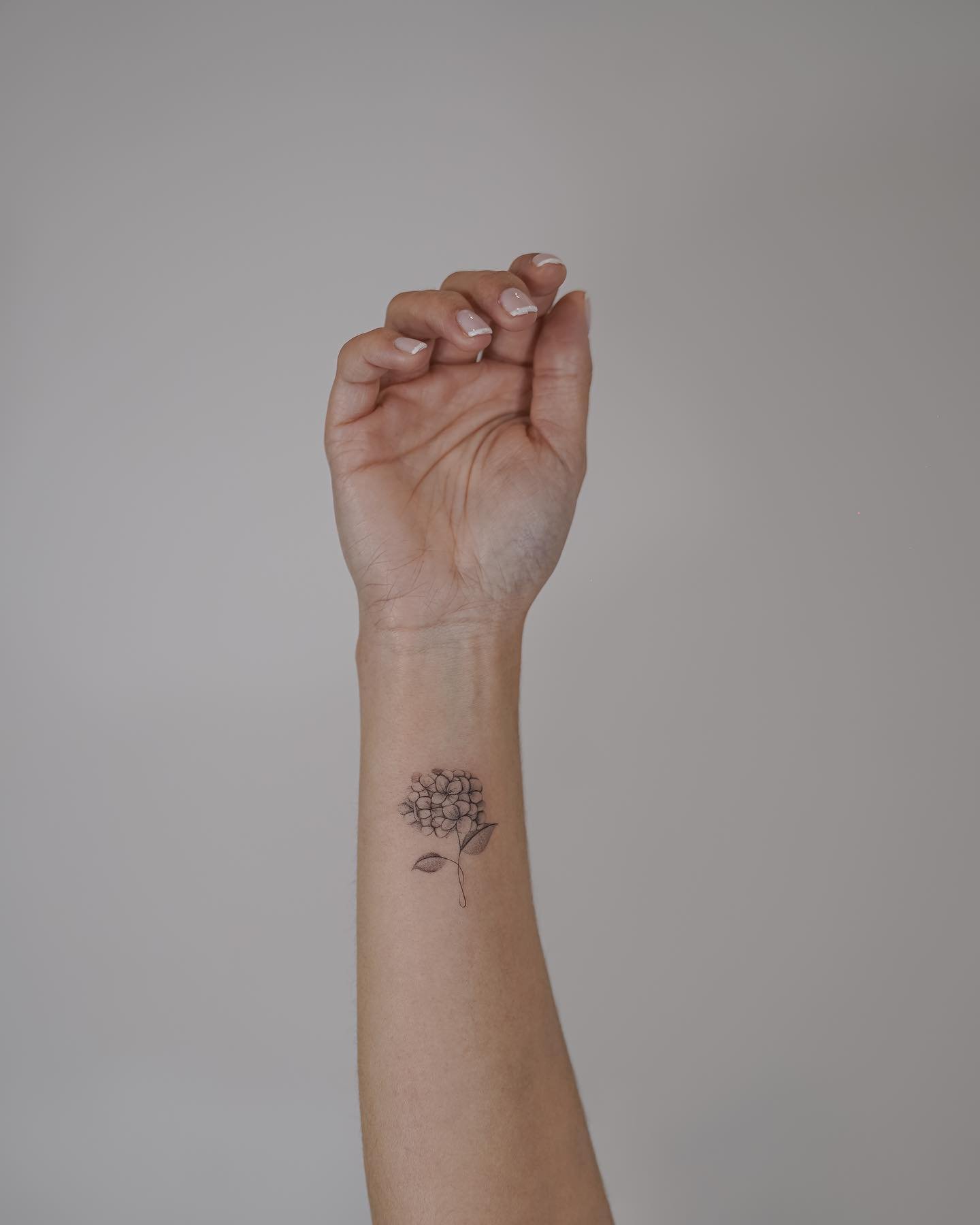 Tatuaje de flor en antebrazo, línea fina Sinkply Madrid