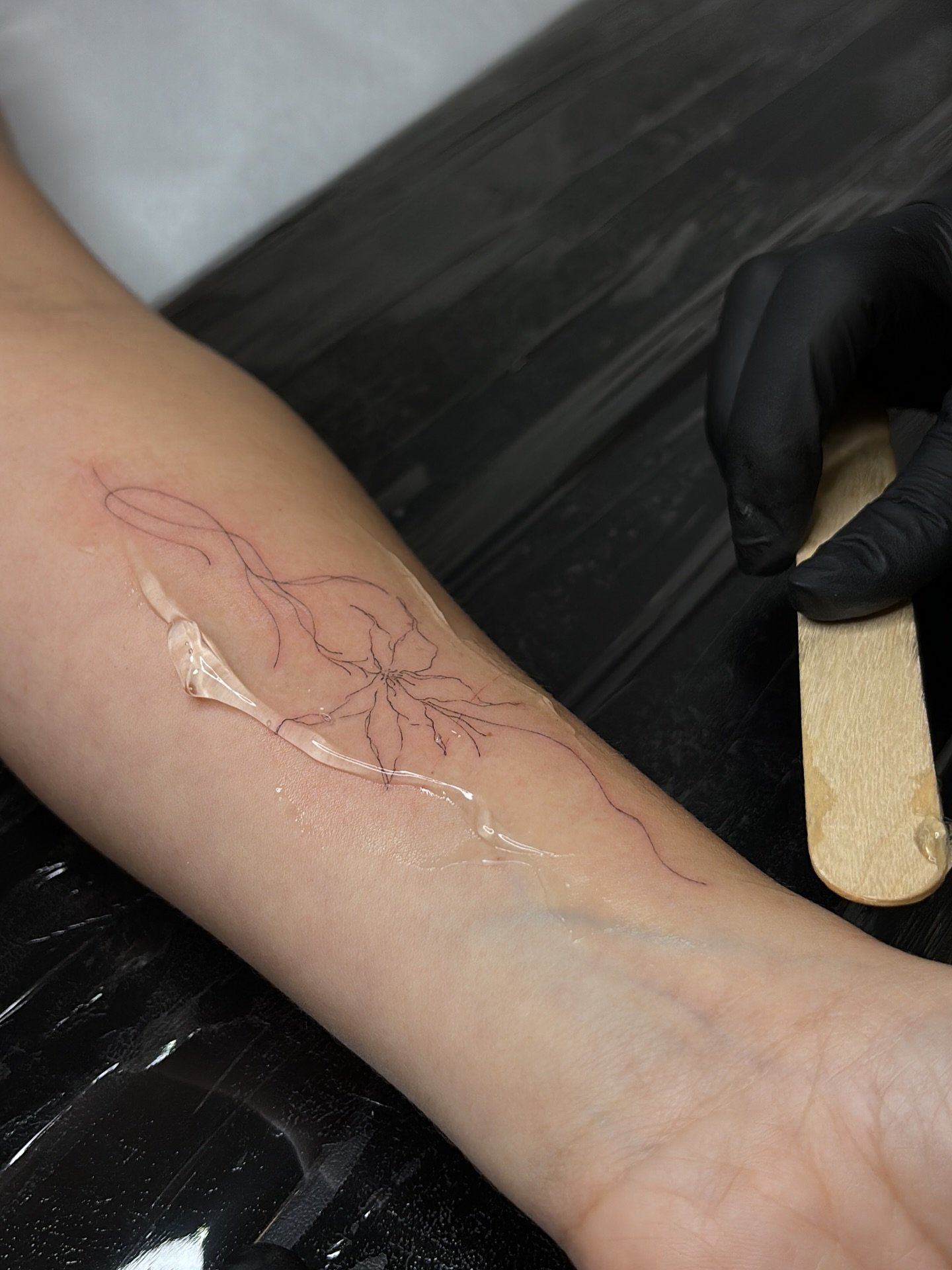 Tatuaje de flor en antebrazo, línea fina Sinkply Madrid