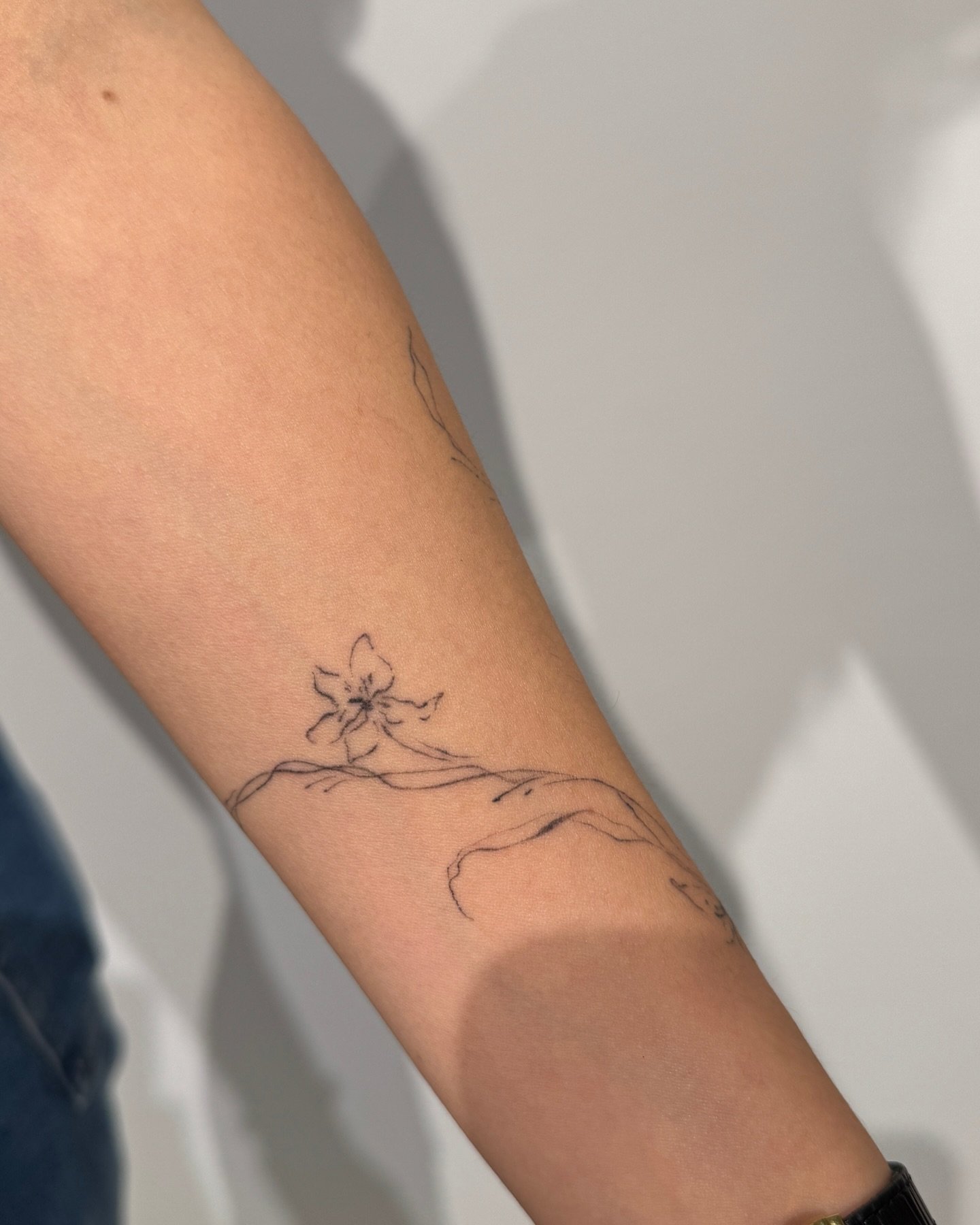 Tatuaje de flor en antebrazo, línea fina Sinkply Madrid