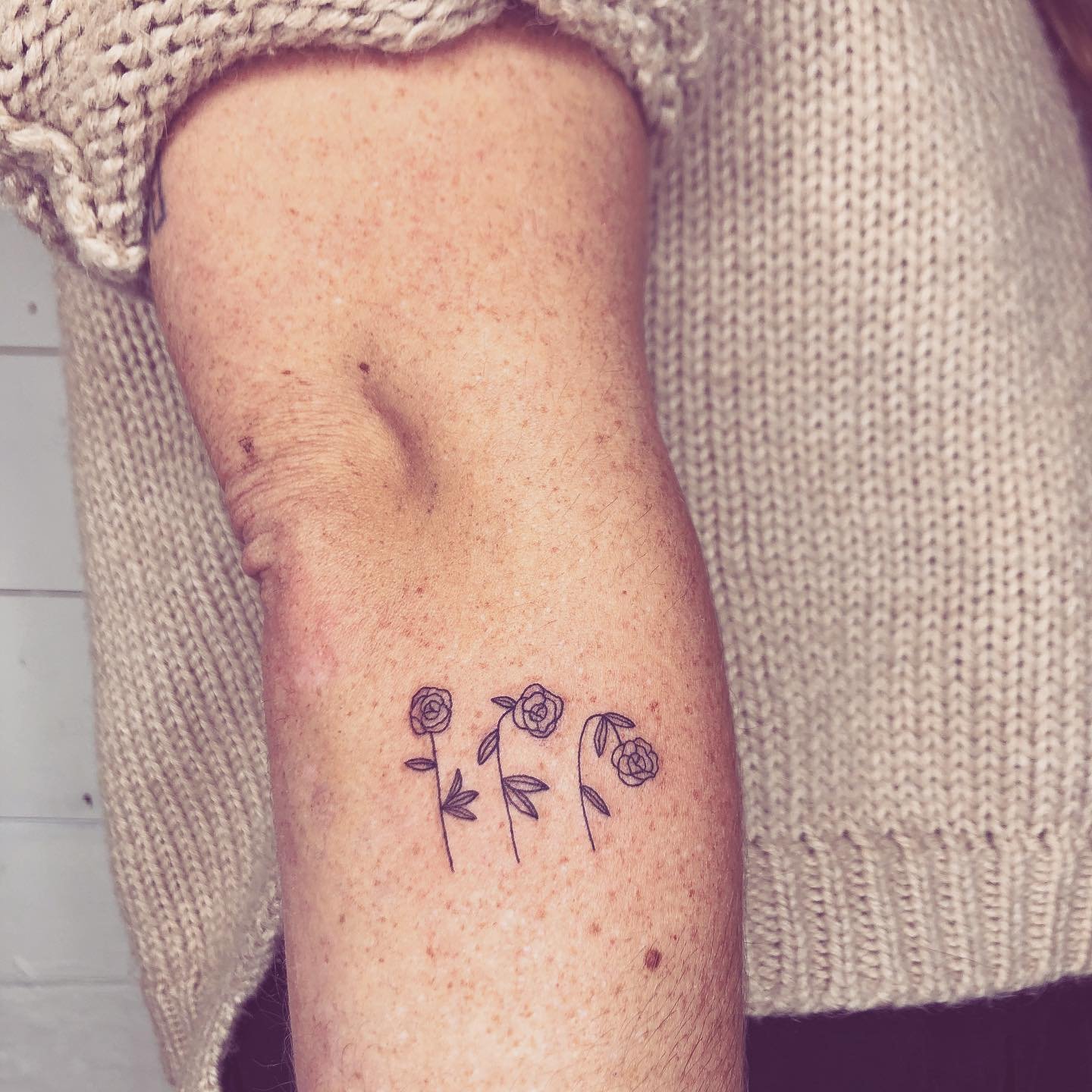 Tatuaje de flor en antebrazo, línea fina Sinkply Madrid