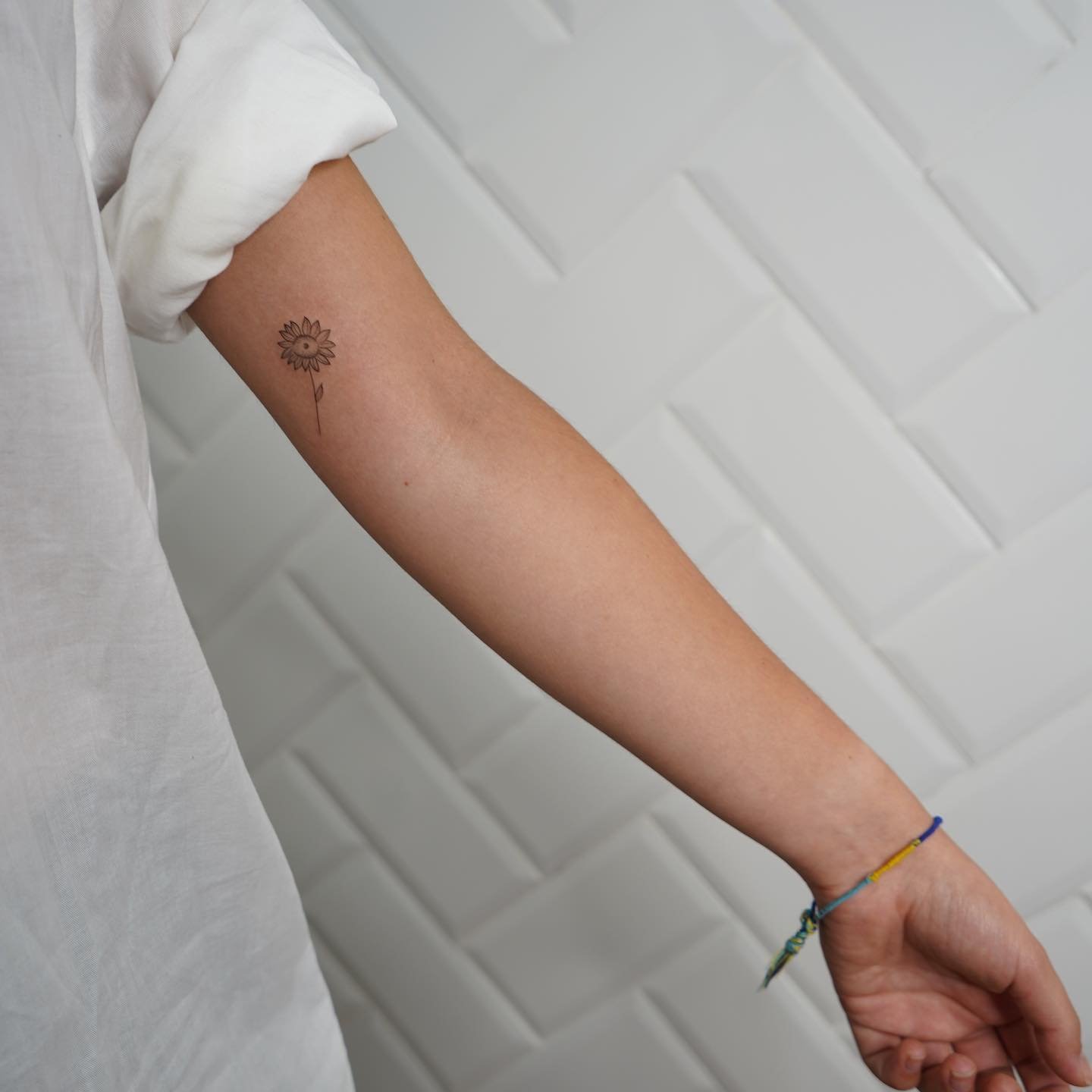 Tatuaje de flor en antebrazo, línea fina Sinkply Madrid