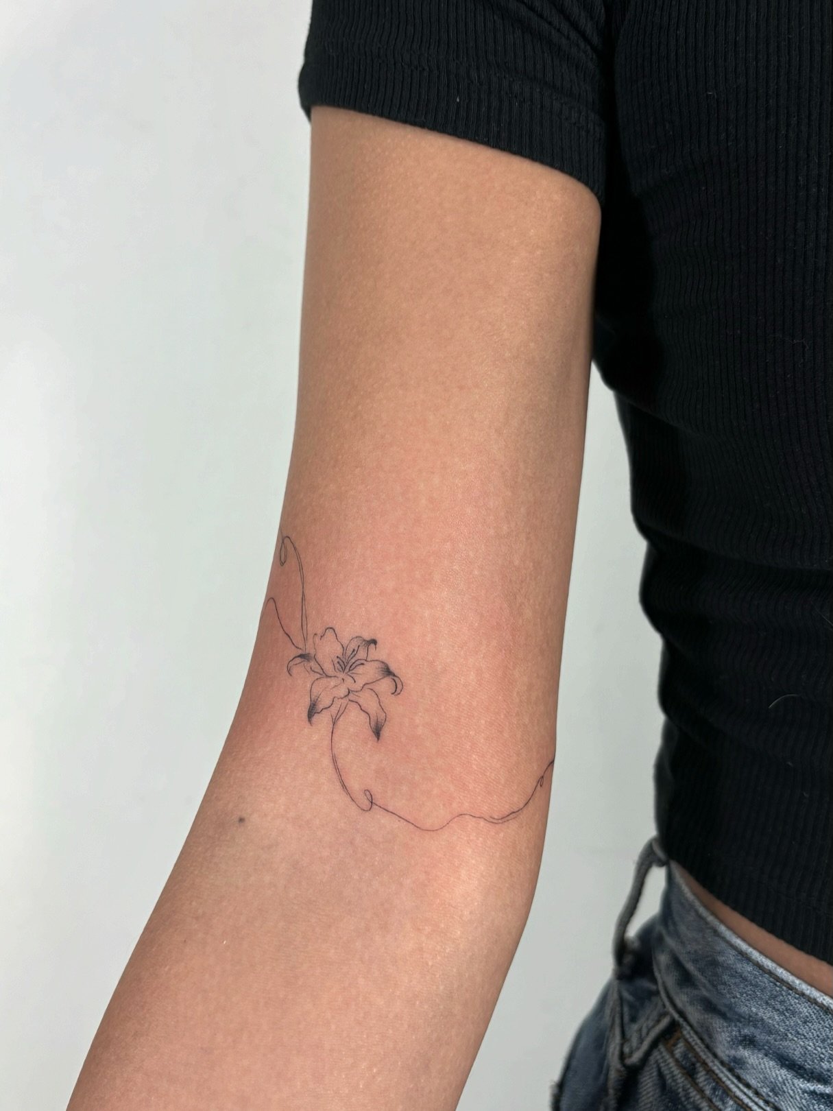 Tatuaje de flor en antebrazo, línea fina Sinkply Madrid