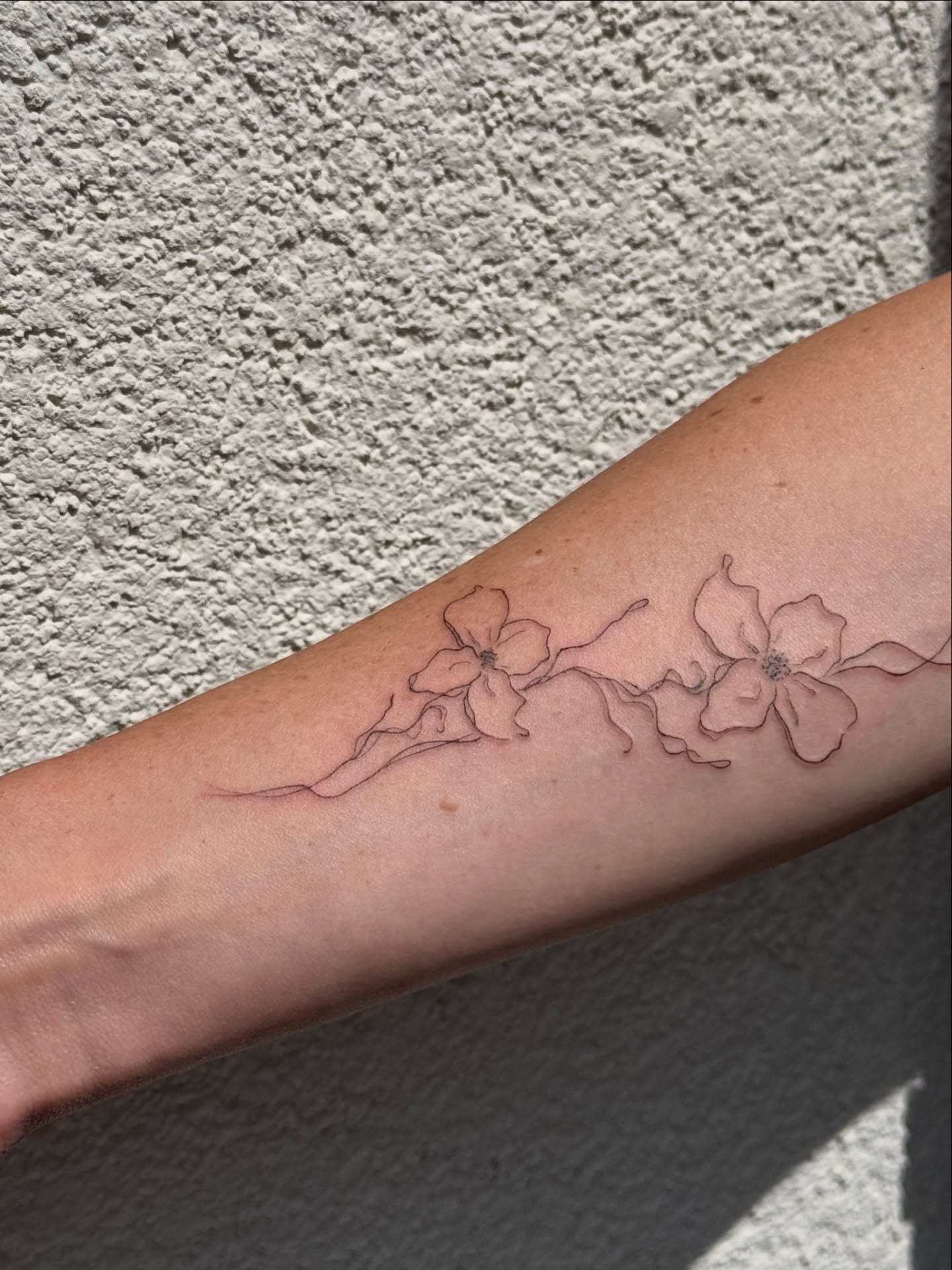 Tatuaje de flor en antebrazo, línea fina Sinkply Madrid