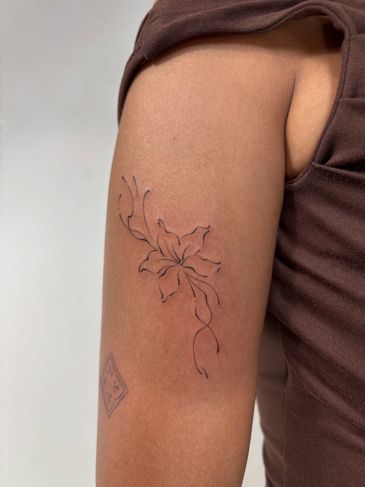Tatuaje de flor en brazo, línea fina Sinkply Madrid