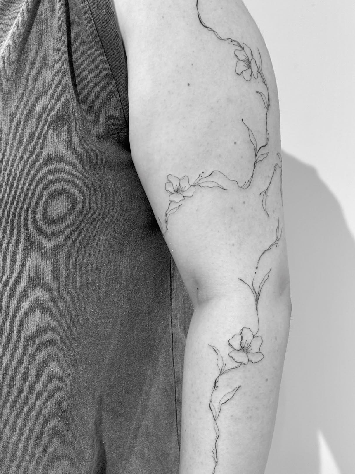 Tatuaje de flor en brazo, línea fina Sinkply Madrid