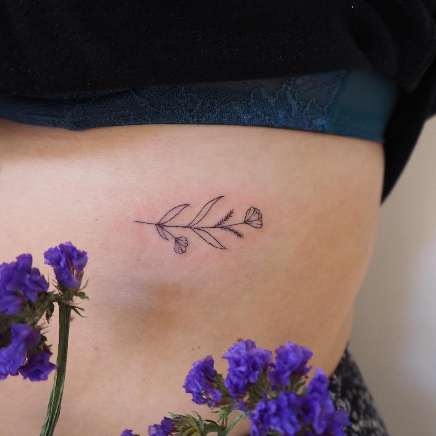 Tatuaje de flor en costilla, línea fina Sinkply Madrid