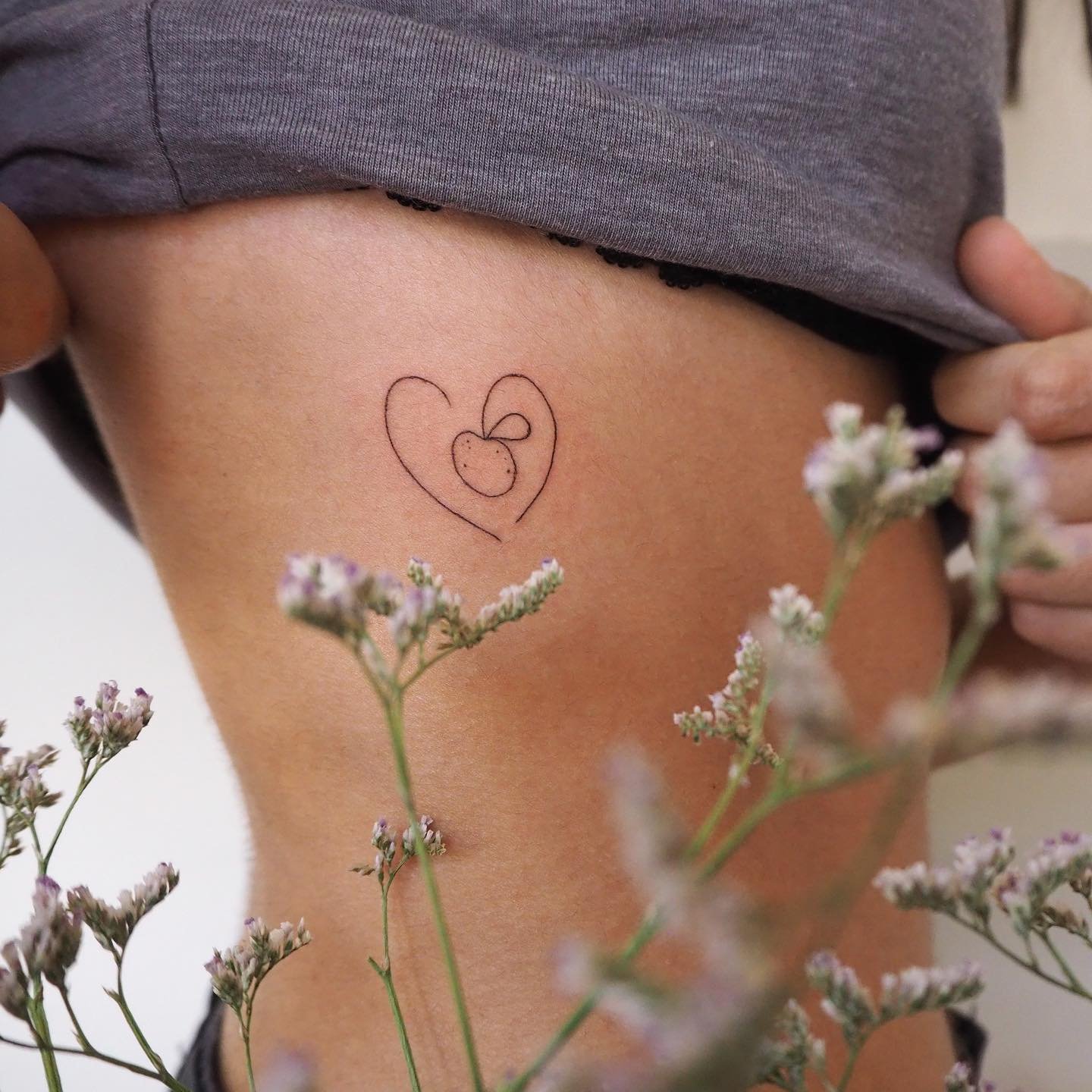 Tatuaje de flor en costilla, línea fina Sinkply Madrid