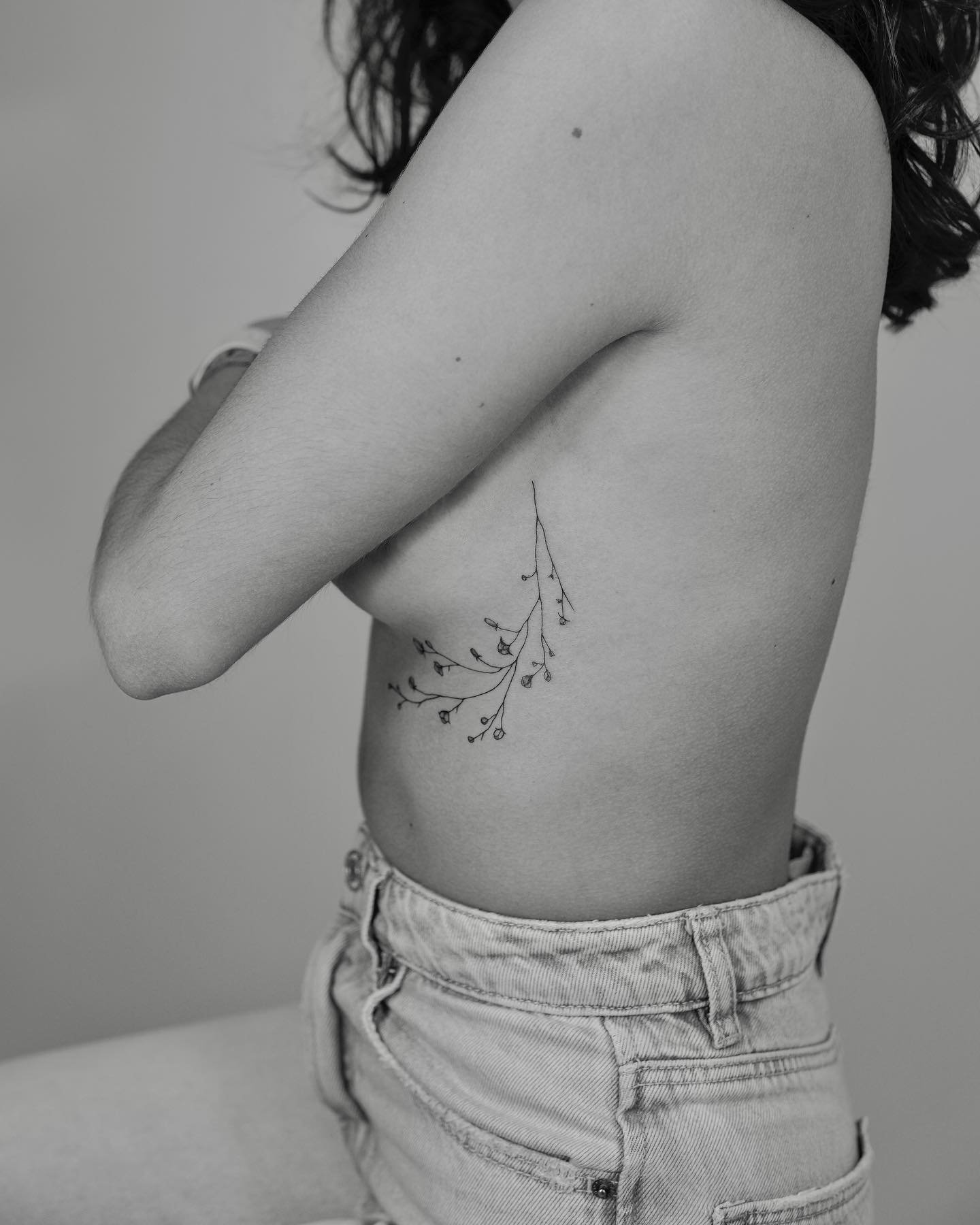 Tatuaje de flor en costilla, línea fina Sinkply Madrid