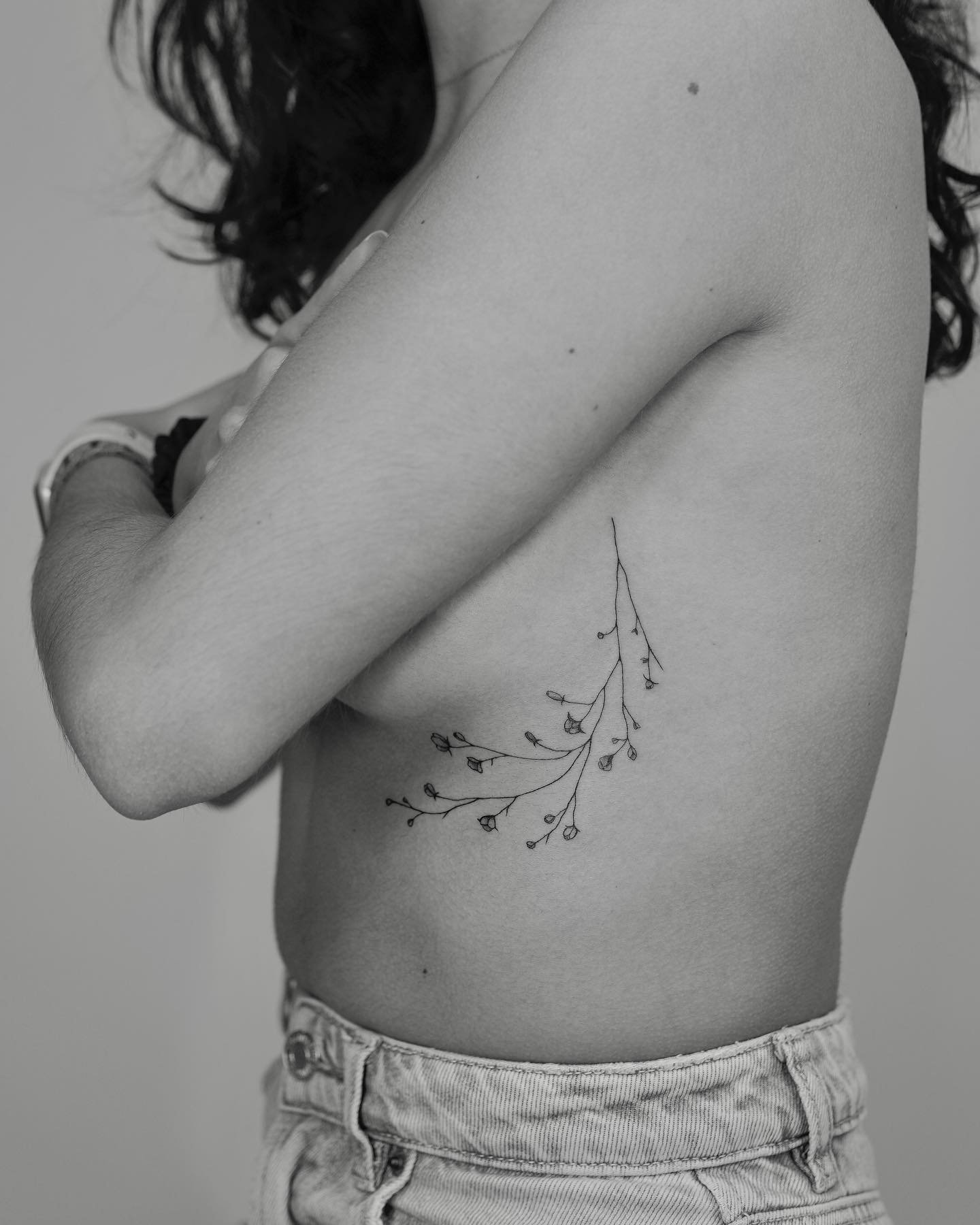 Tatuaje de flor en costilla, línea fina Sinkply Madrid