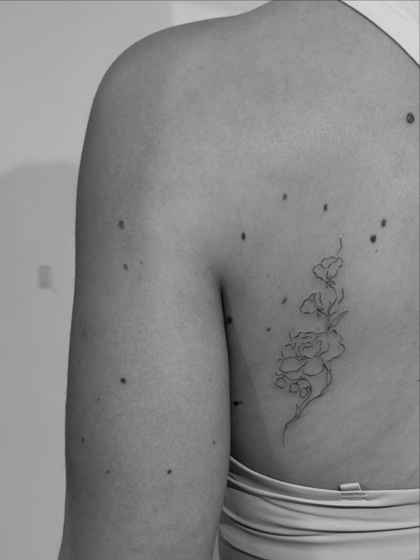 Tatuaje de flor en costilla, línea fina Sinkply Madrid