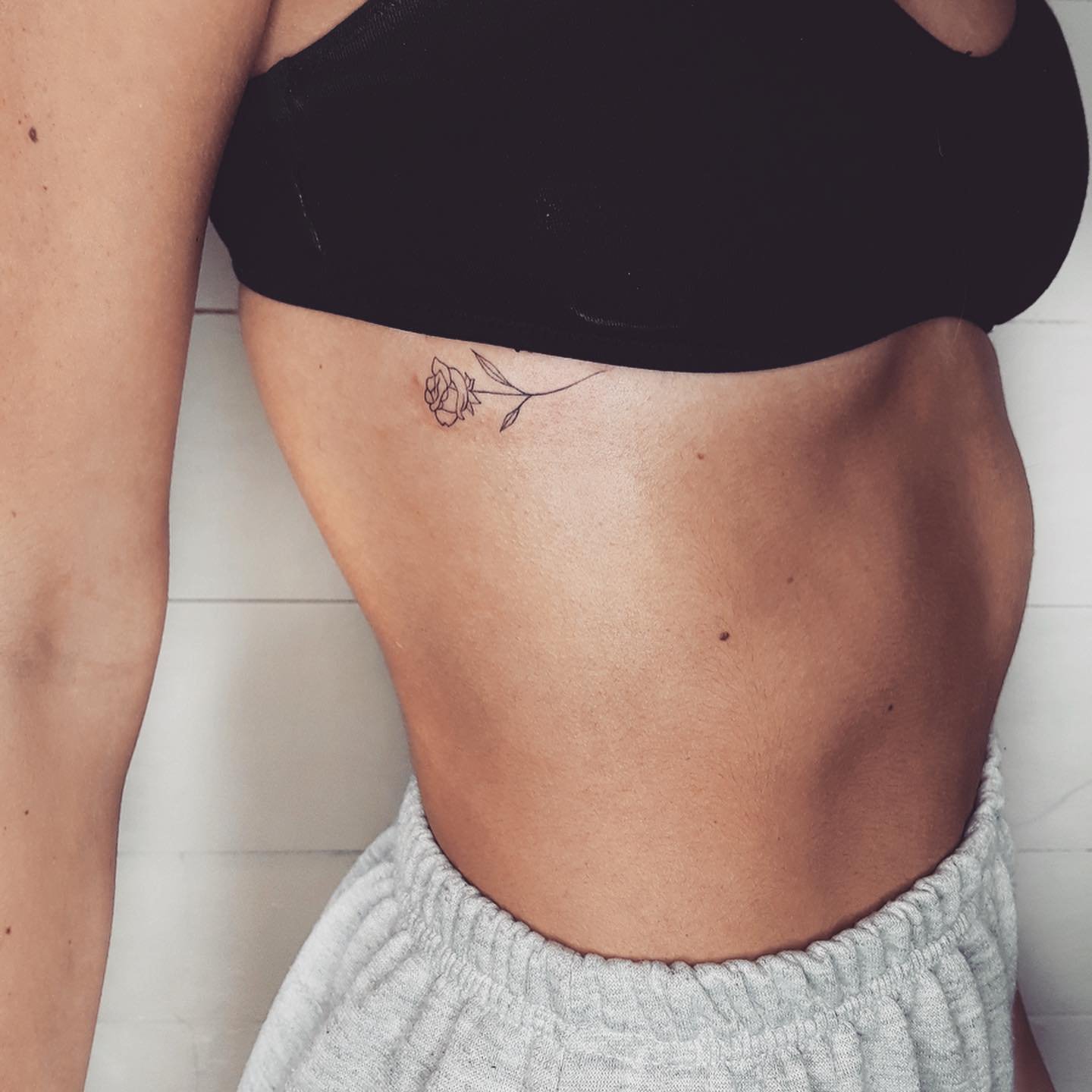 Tatuaje de flor en costilla, línea fina Sinkply Madrid
