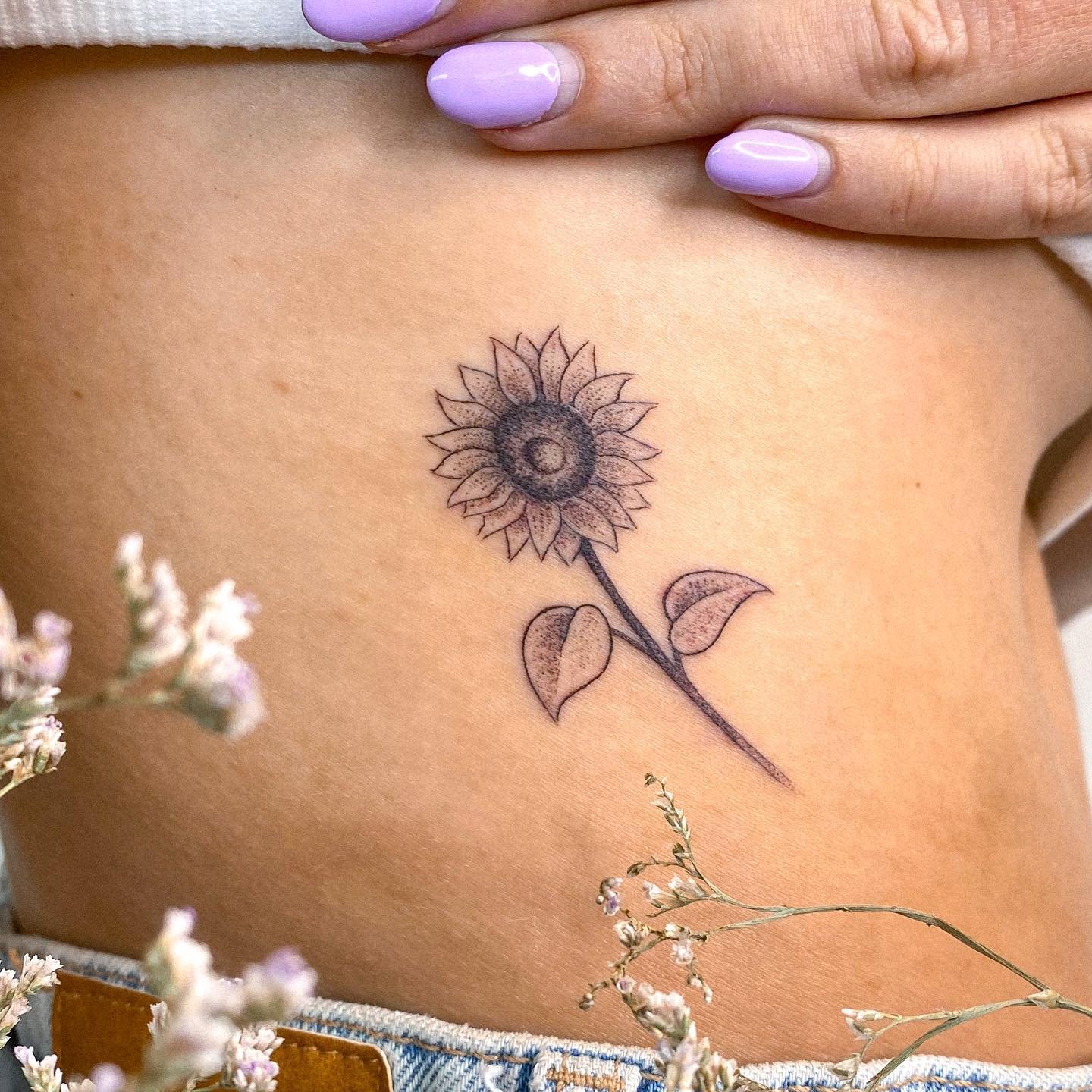 Tatuaje de flor en costilla, línea fina Sinkply Madrid