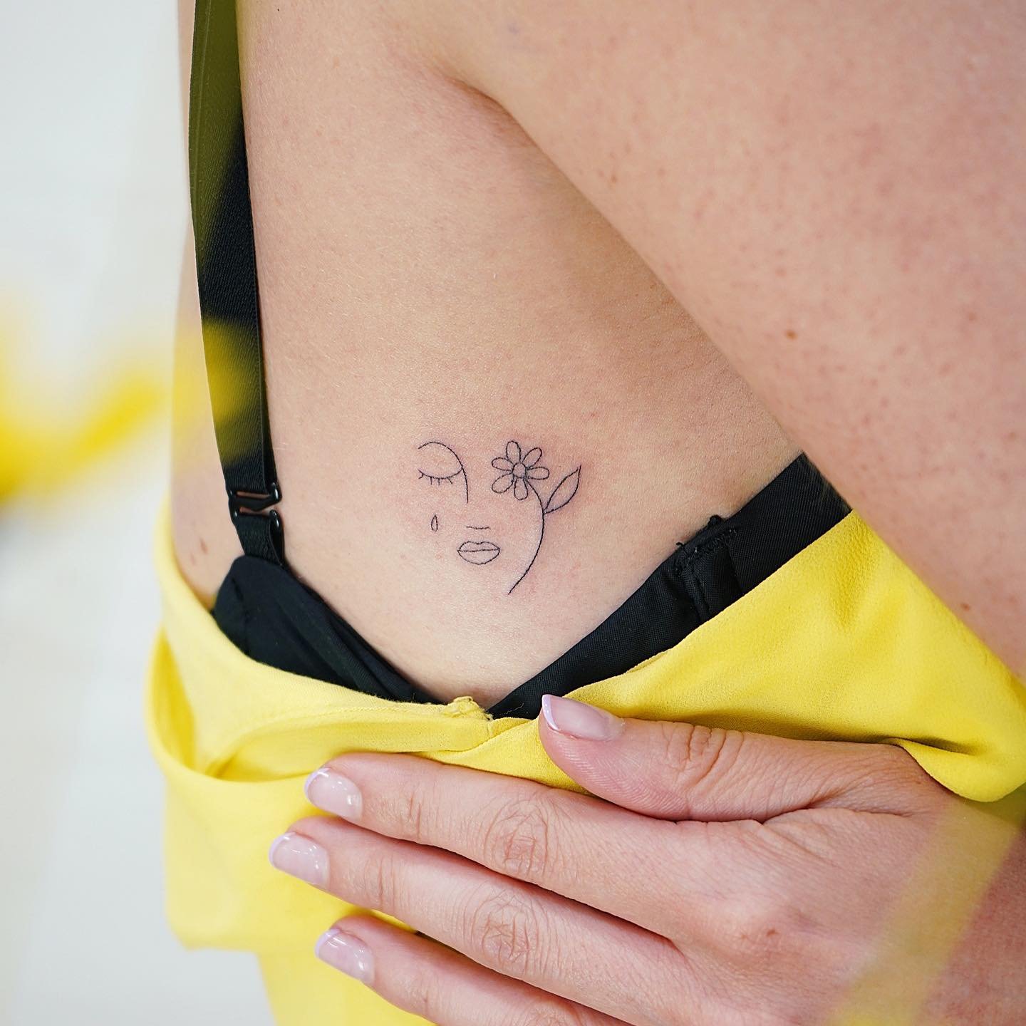 Tatuaje de flor en costilla, línea fina Sinkply Madrid