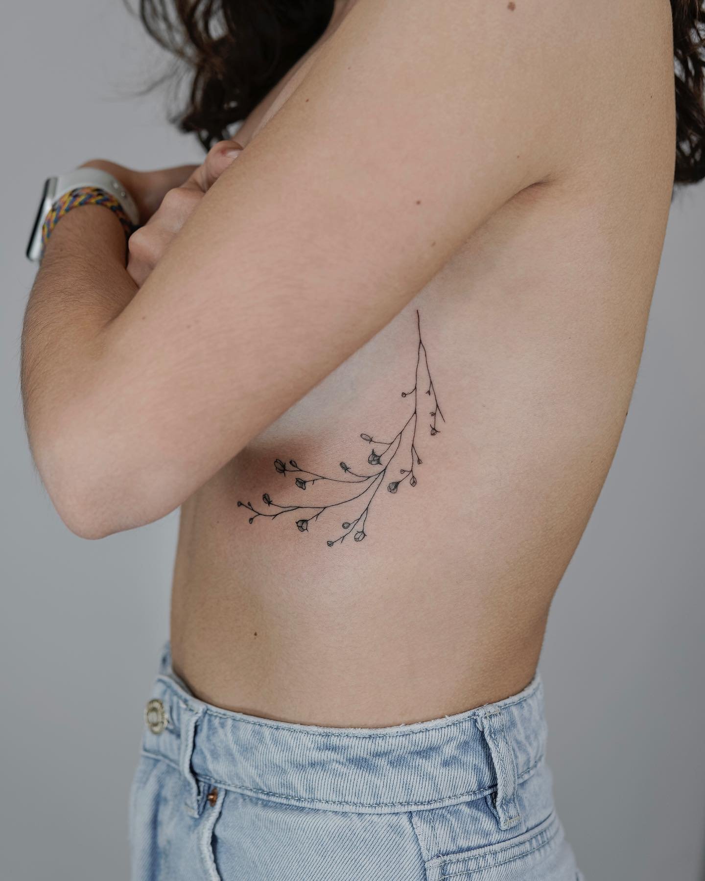 Tatuaje de flor en costilla, línea fina Sinkply Madrid