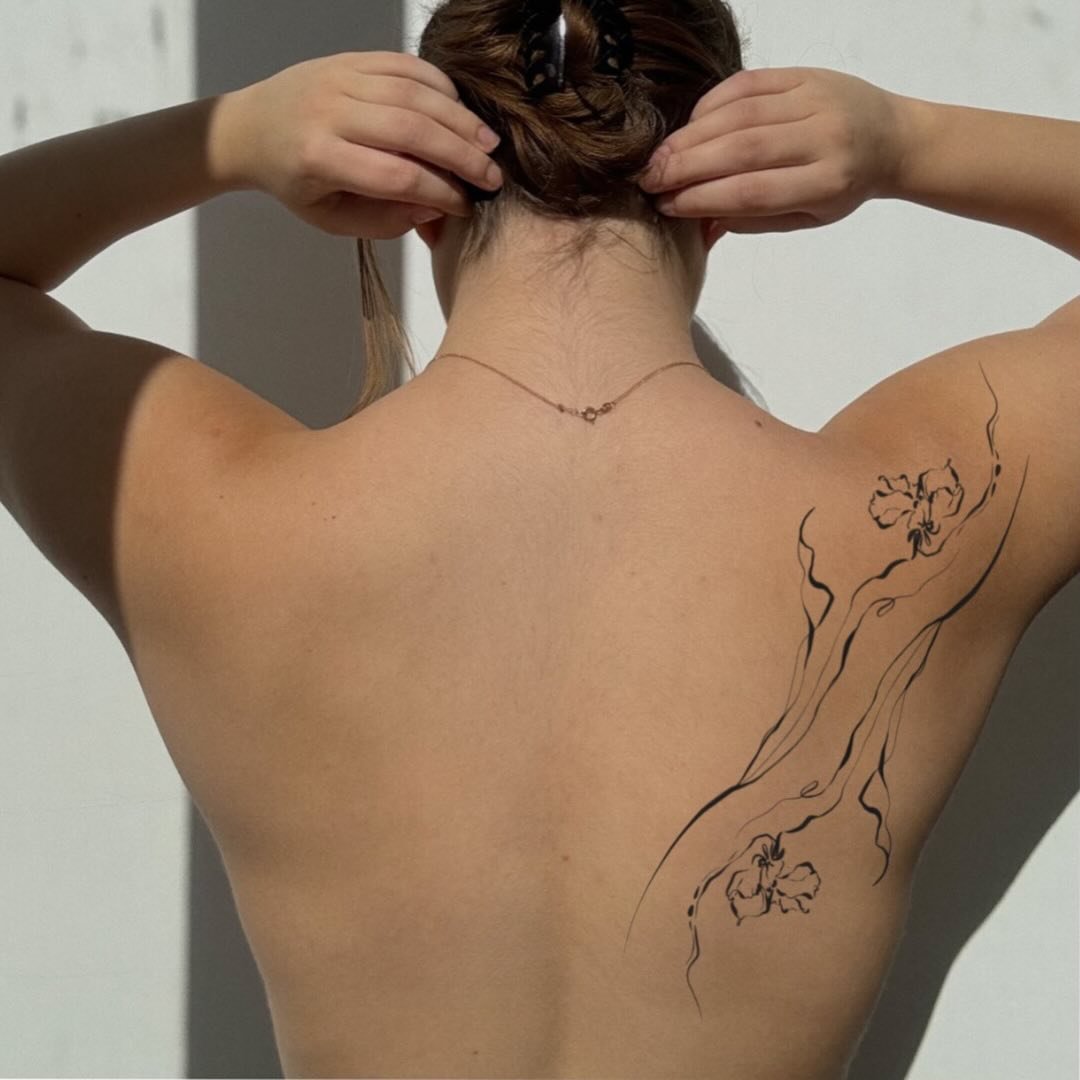 Tatuaje de flor en costilla, línea fina Sinkply Madrid