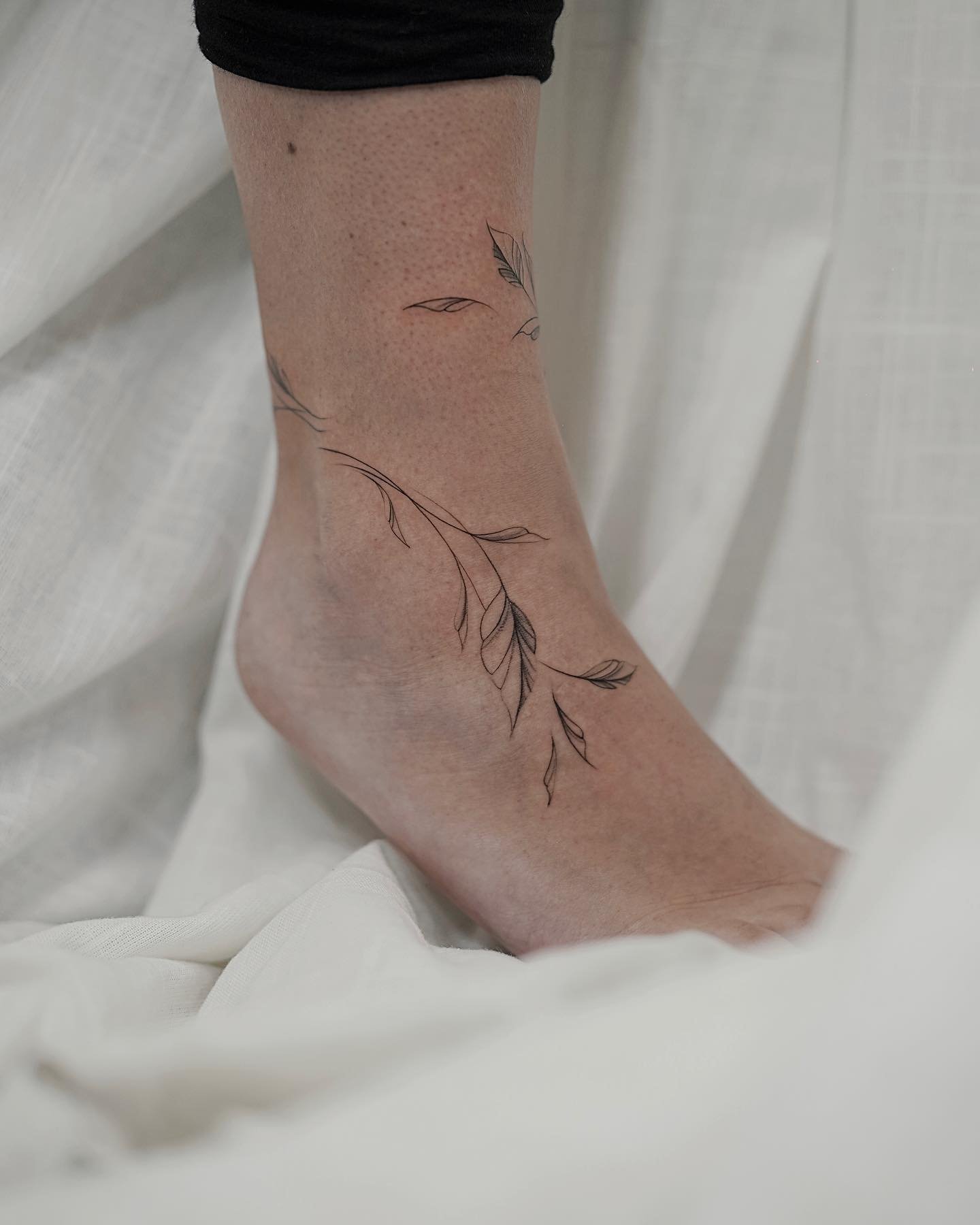 Tatuaje de rama en tobillo, línea fina Sinkply Madrid