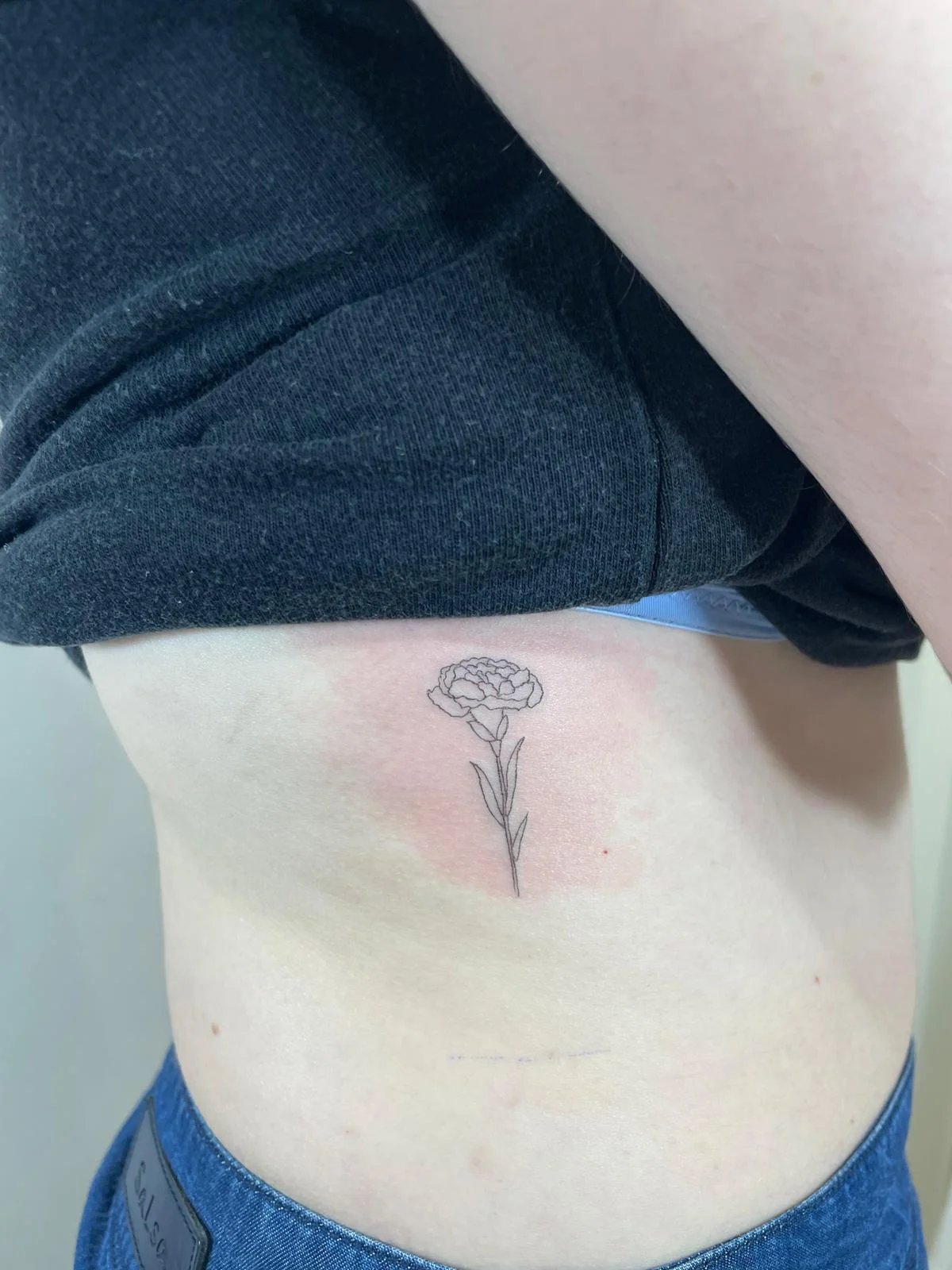 Tatuaje floral clavel con tallo costillas
