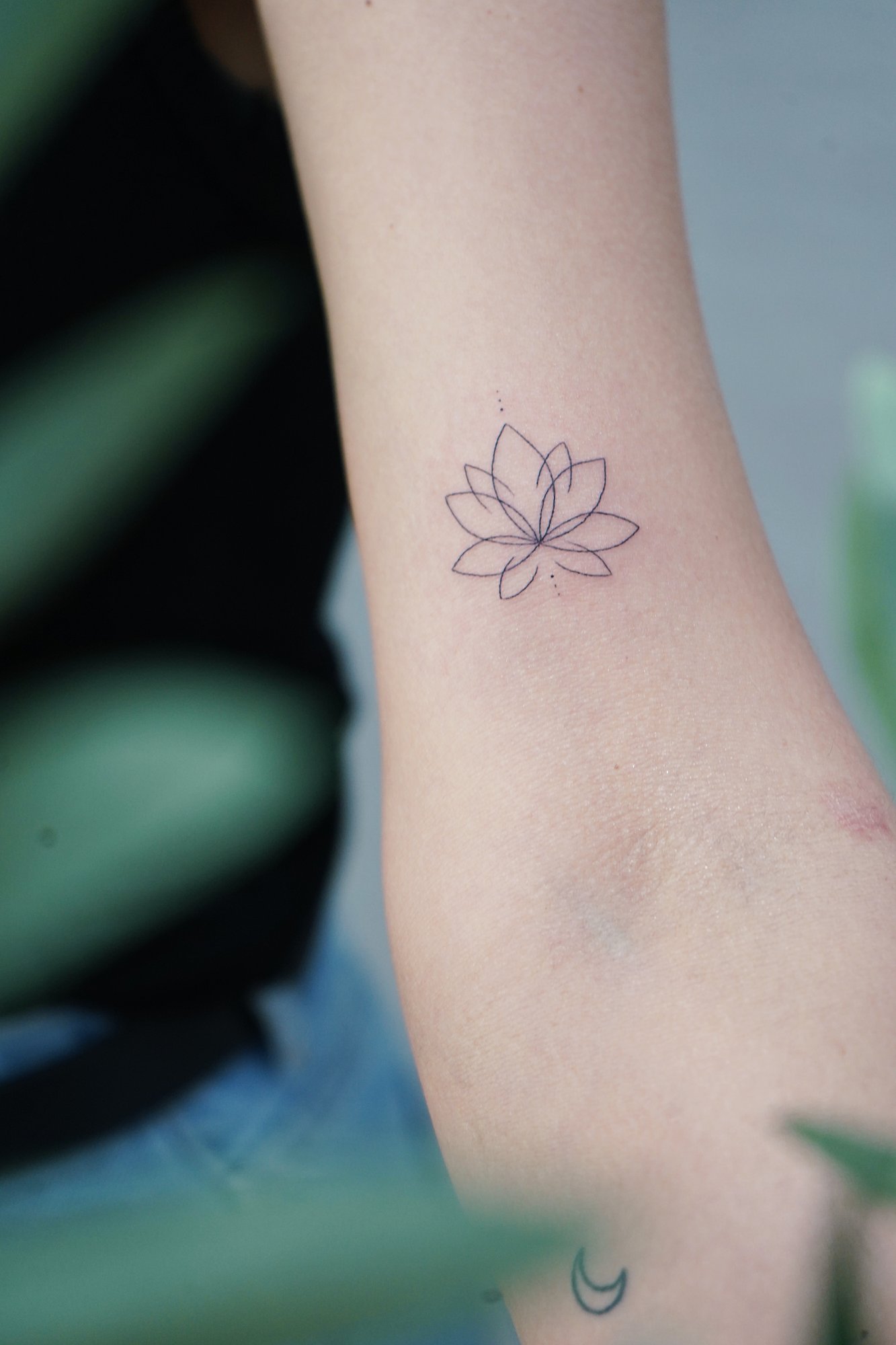 Tatuaje de flor loto en brazo, línea fina