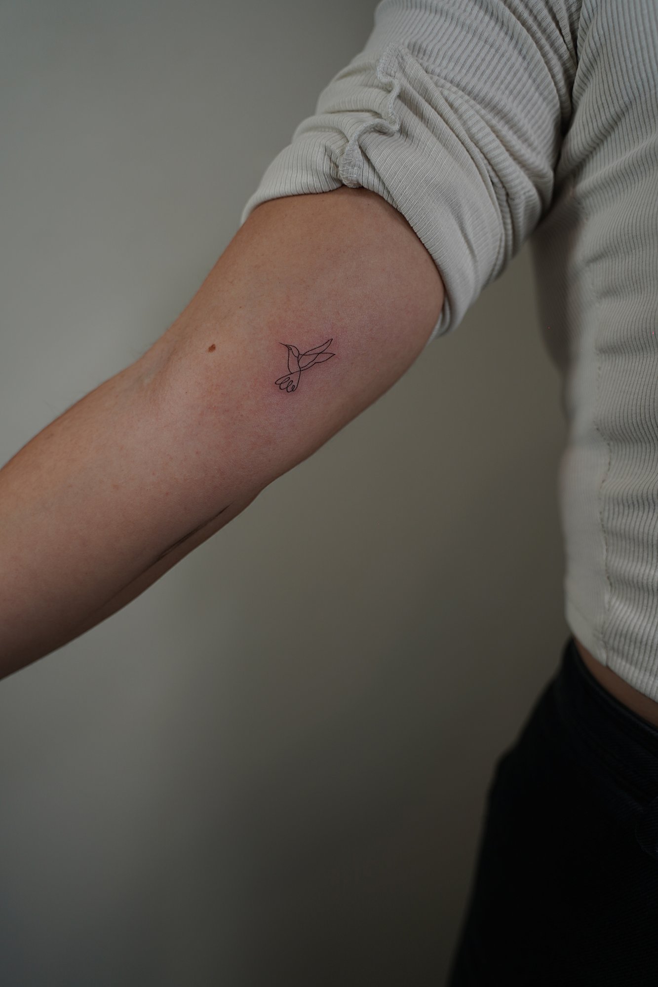 Tatuaje de flor loto en muneca, línea fina